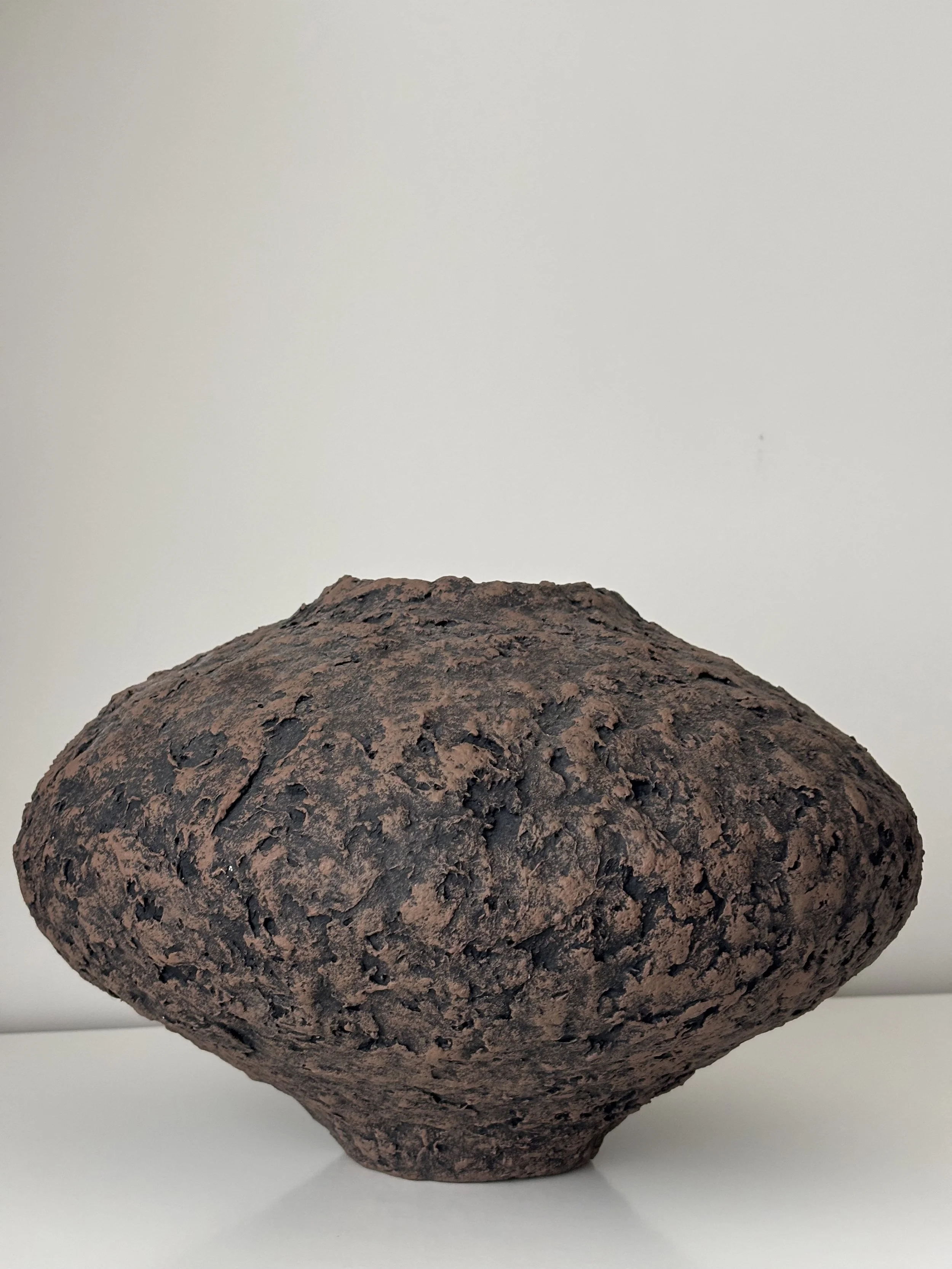 Wabi Sabi Vase N.44 from an angled perspective, off-white sculptural paper clay vase with irregular organic edges, unique handcrafted pottery