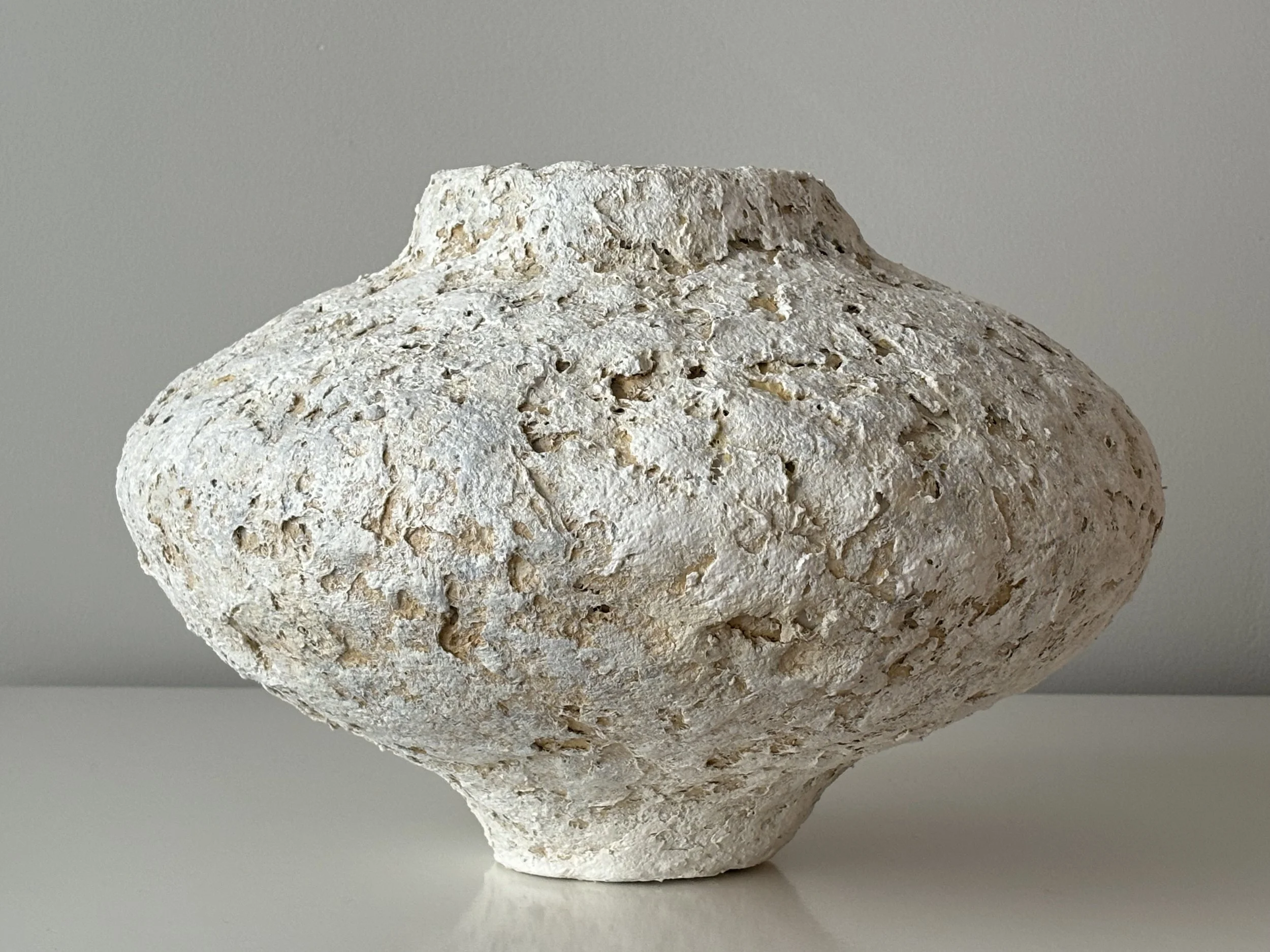 Contemporary Textured Vessel N.75, off-white paper clay vessel viewed from an alternate angle highlighting asymmetrical shape, from Papier Atelier London