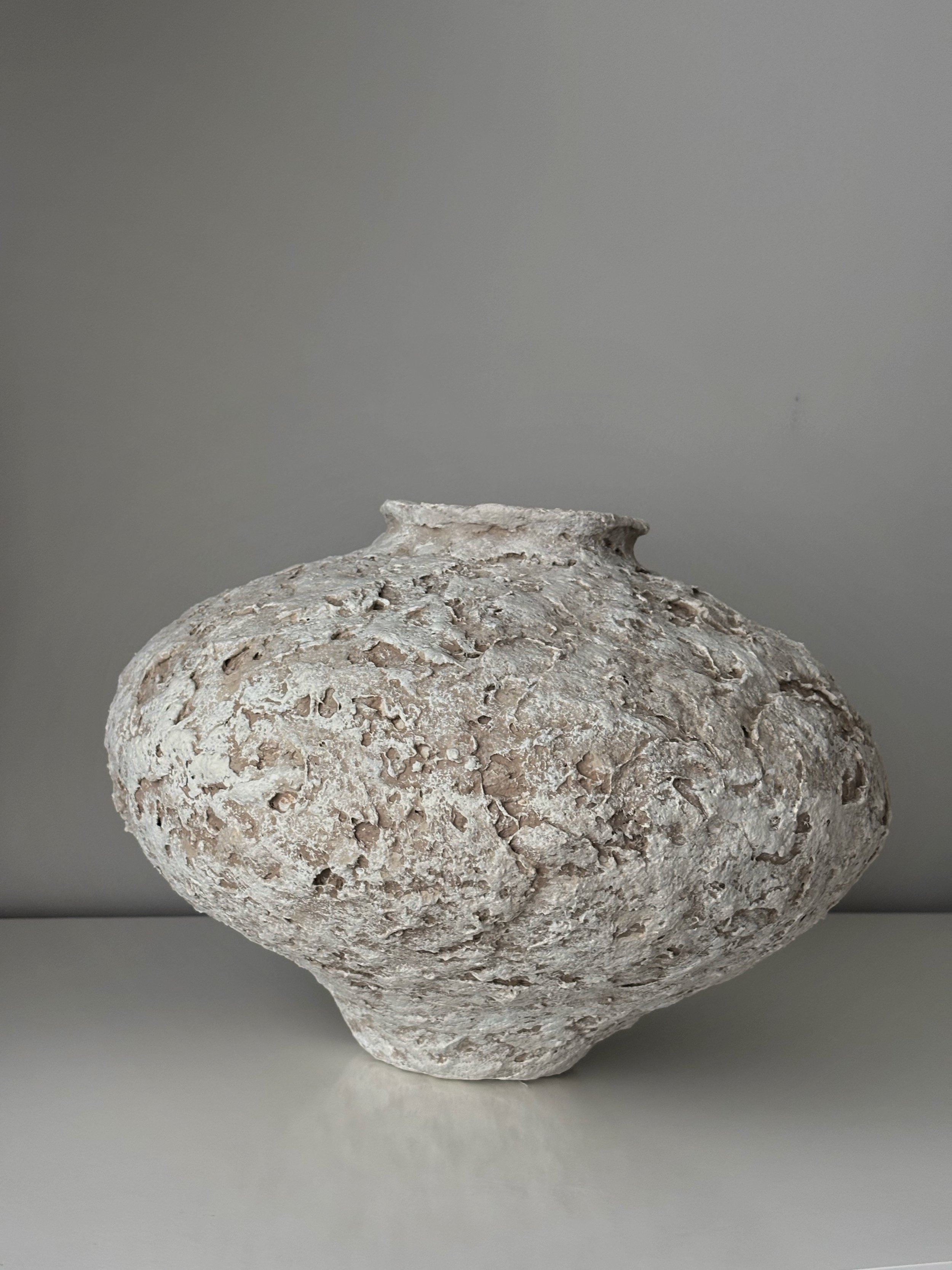 Three-quarter view of Sculptural Vessel N.20, off-white textured paper clay vessel with organic irregular form, minimalist sculptural home decor