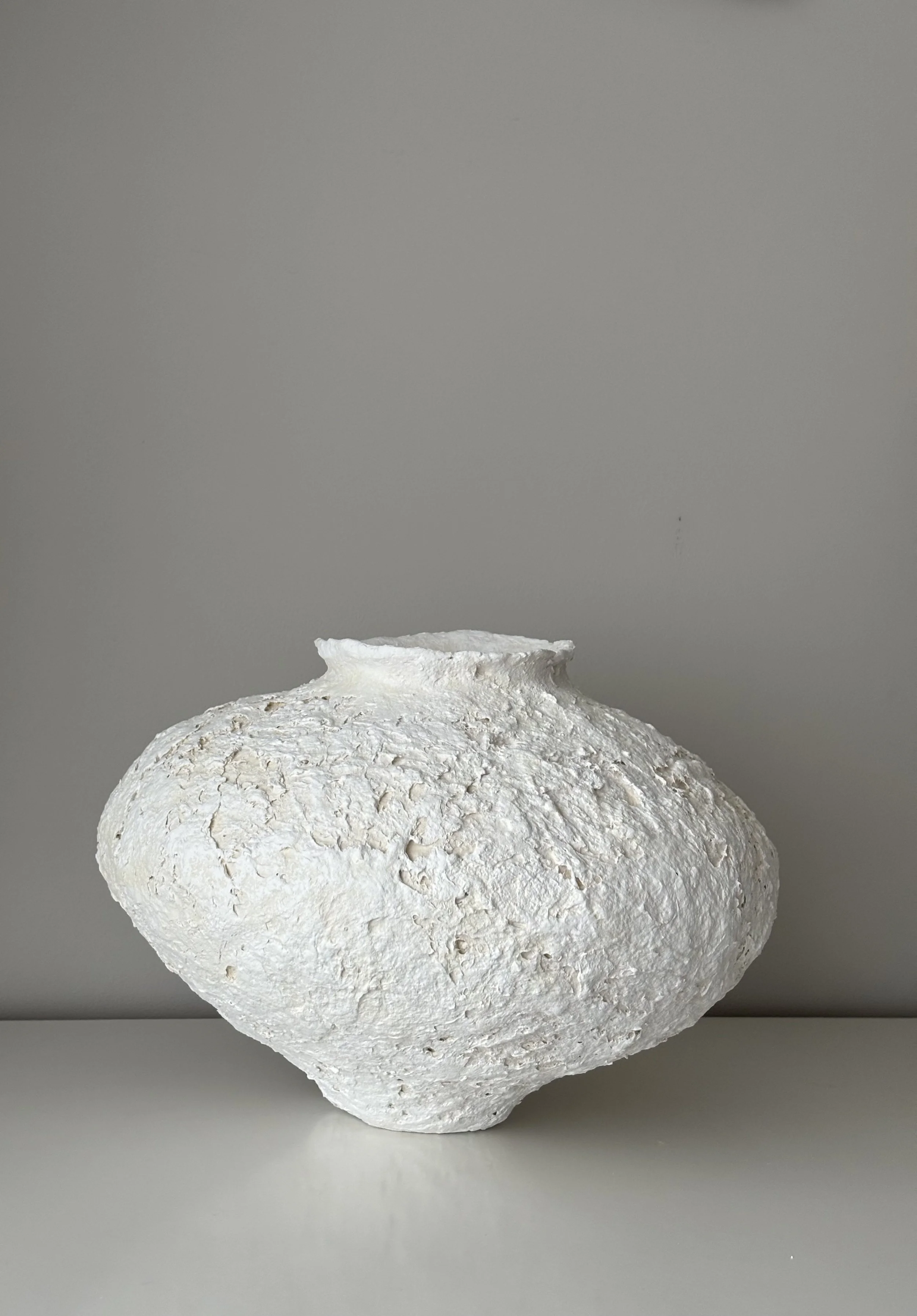 Three-quarter view of Textured Organic Vessel N.38, off-white textured paper clay vessel with organic irregular form, minimalist sculptural home decor