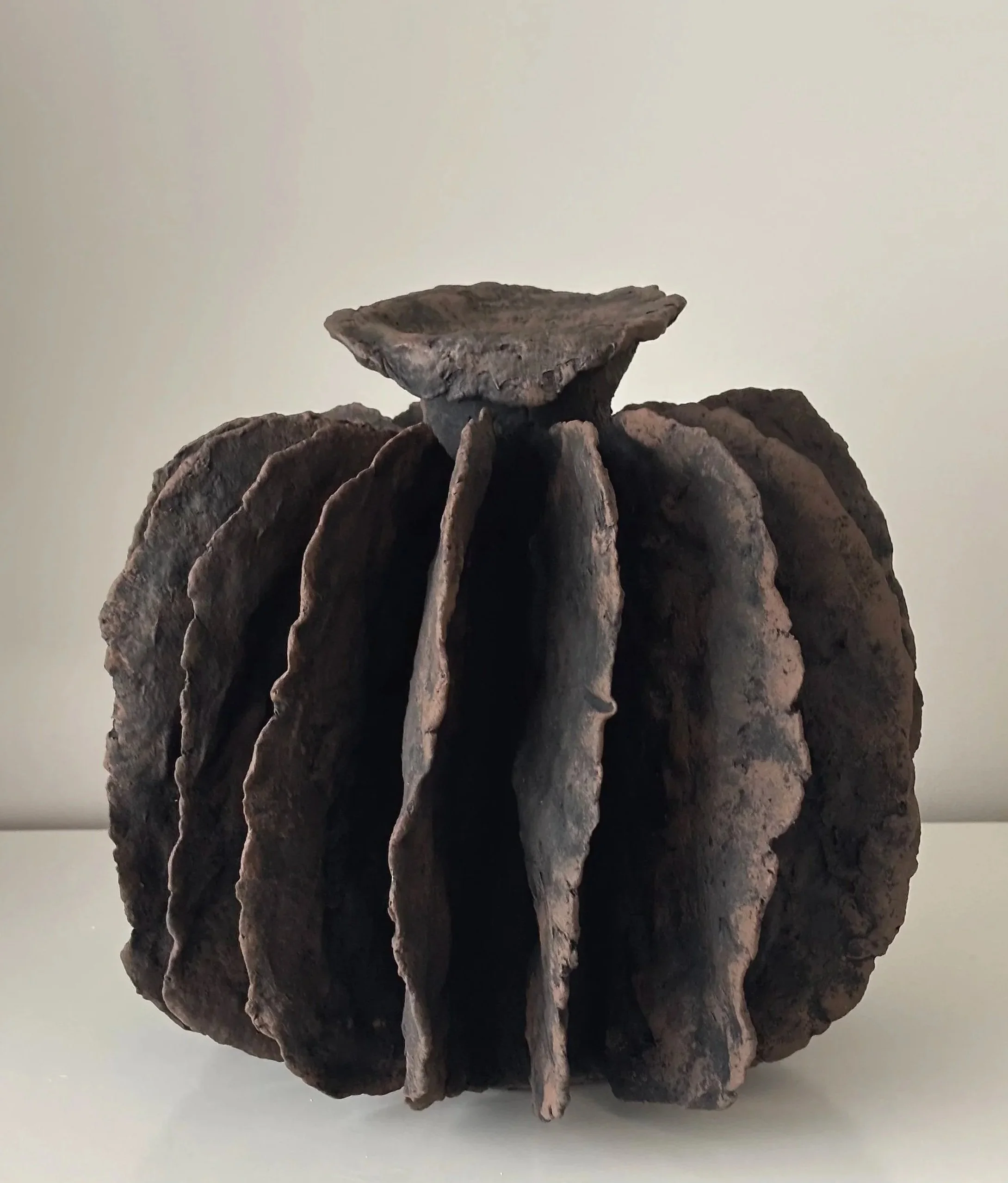 Textured Pleated Vessel N.8, off-white paper clay vessel viewed from an alternate angle highlighting asymmetrical shape, from Papier Atelier London