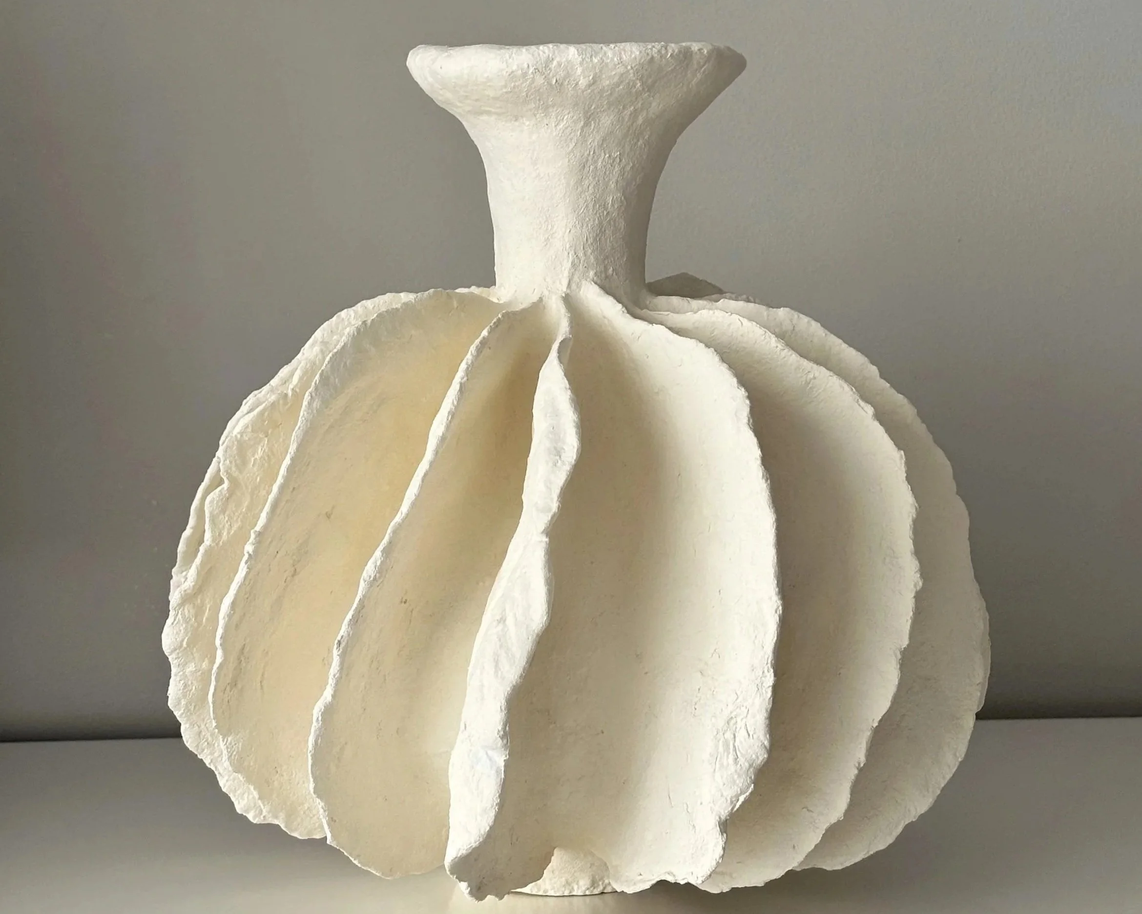Side profile of Pleated Sculptural Vase N.10 in Wabi-Sabi inspired paper clay, showing the sculptural silhouette and textured surface, London atelier