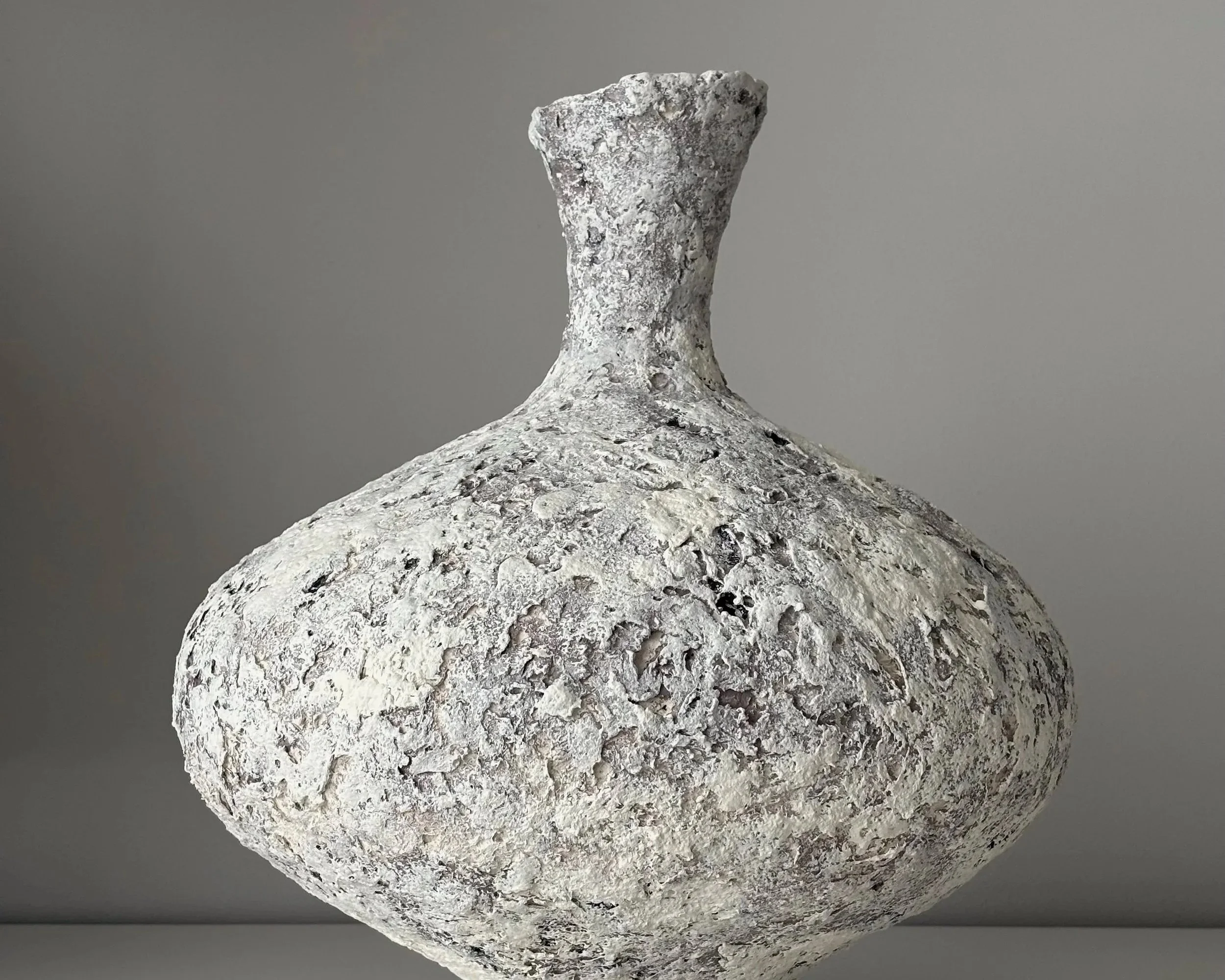 Three-quarter view of Wabi Sabi Vase N.11, off-white sculptural paper clay vase with organic irregular form, unique handcrafted pottery