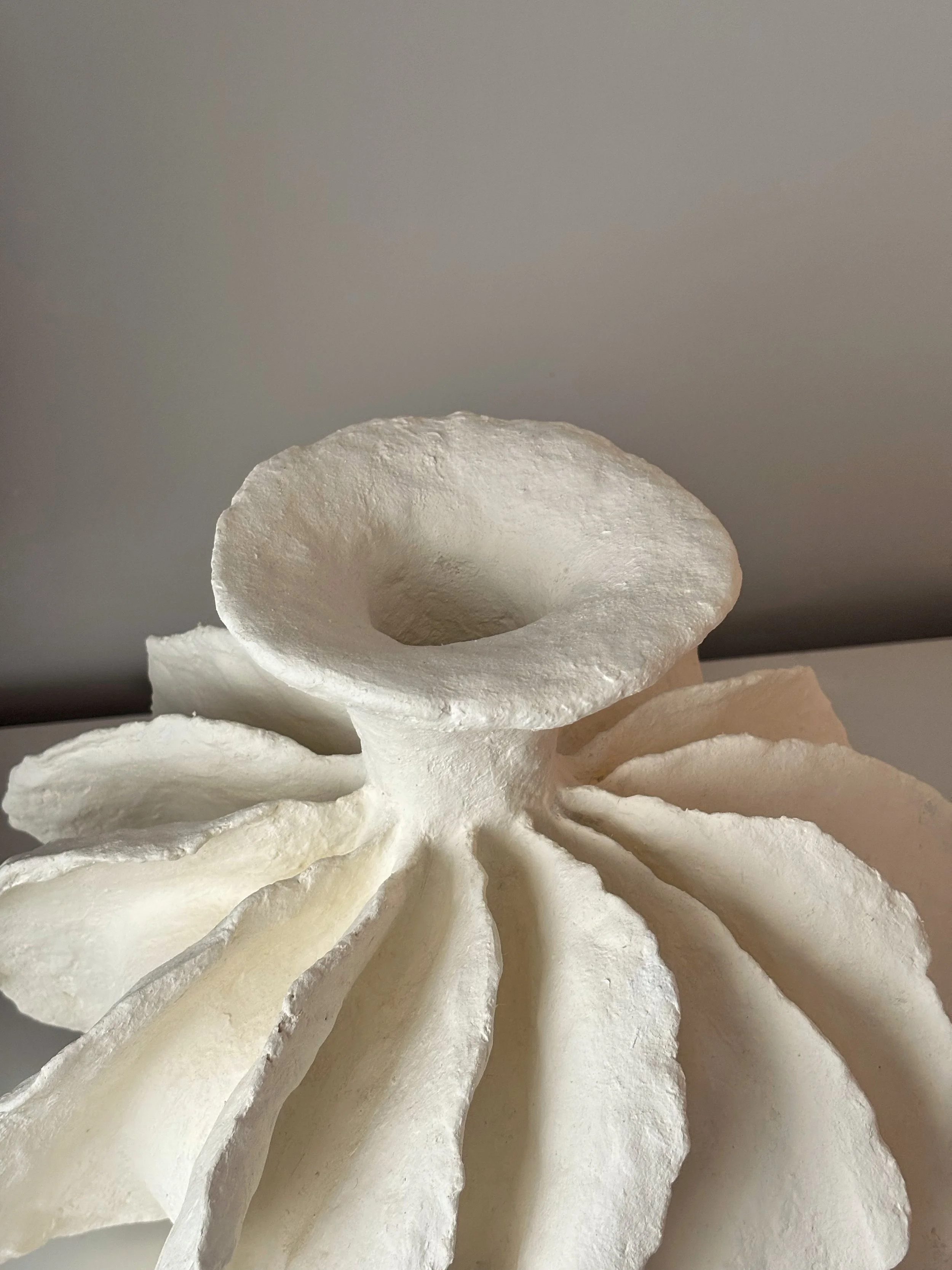 Pleated Sculptural Vase N.10, off-white paper clay vase viewed from an alternate angle highlighting asymmetrical shape, from Papier Atelier London