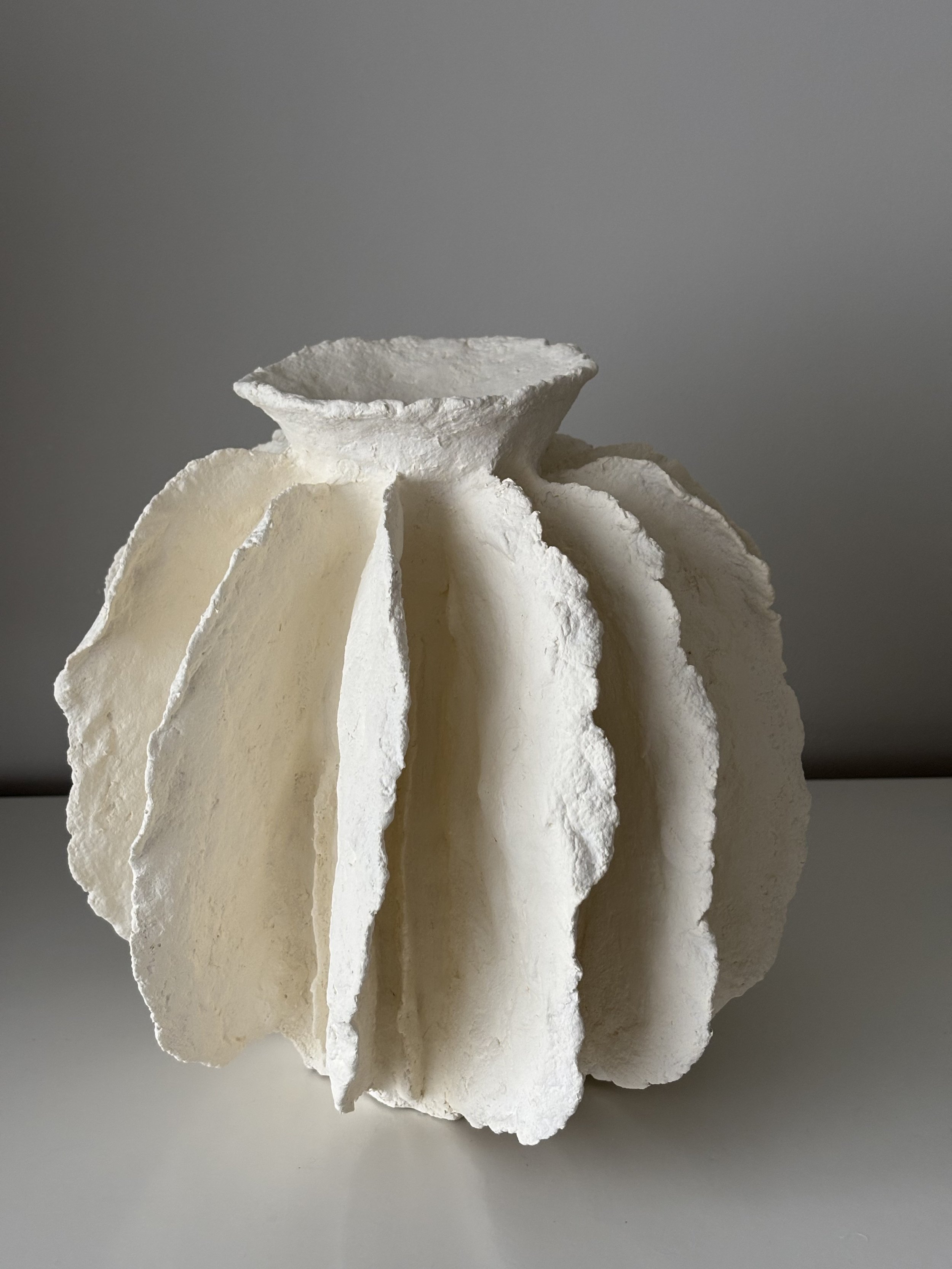 Rear view of White Sculptural Pleated Vessel N.43 in white paper clay, showing organic asymmetry from behind, from Papier Atelier London