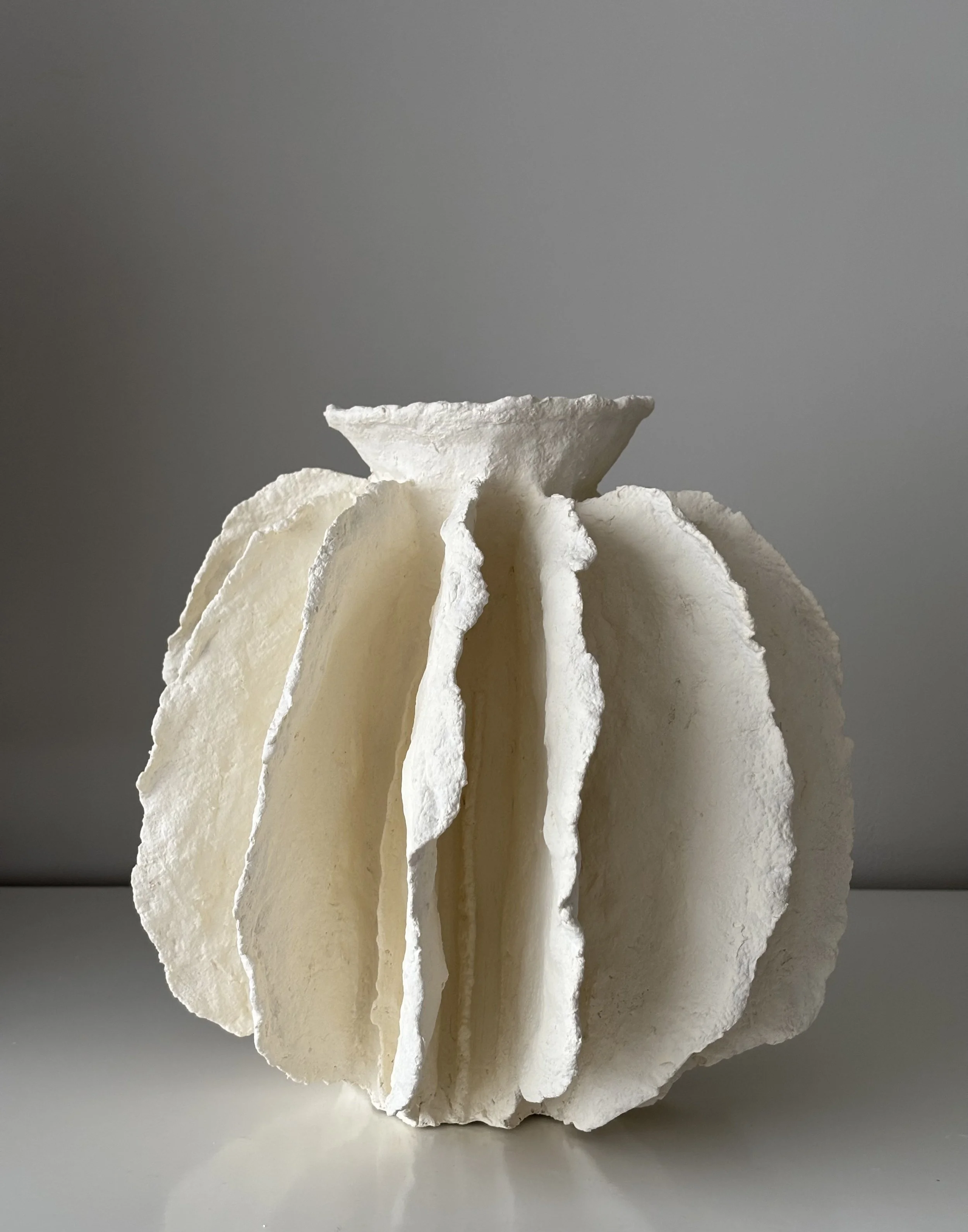 Side profile of White Sculptural Pleated Vessel N.43 in Wabi-Sabi inspired paper clay, showing the sculptural silhouette and textured surface, London atelier