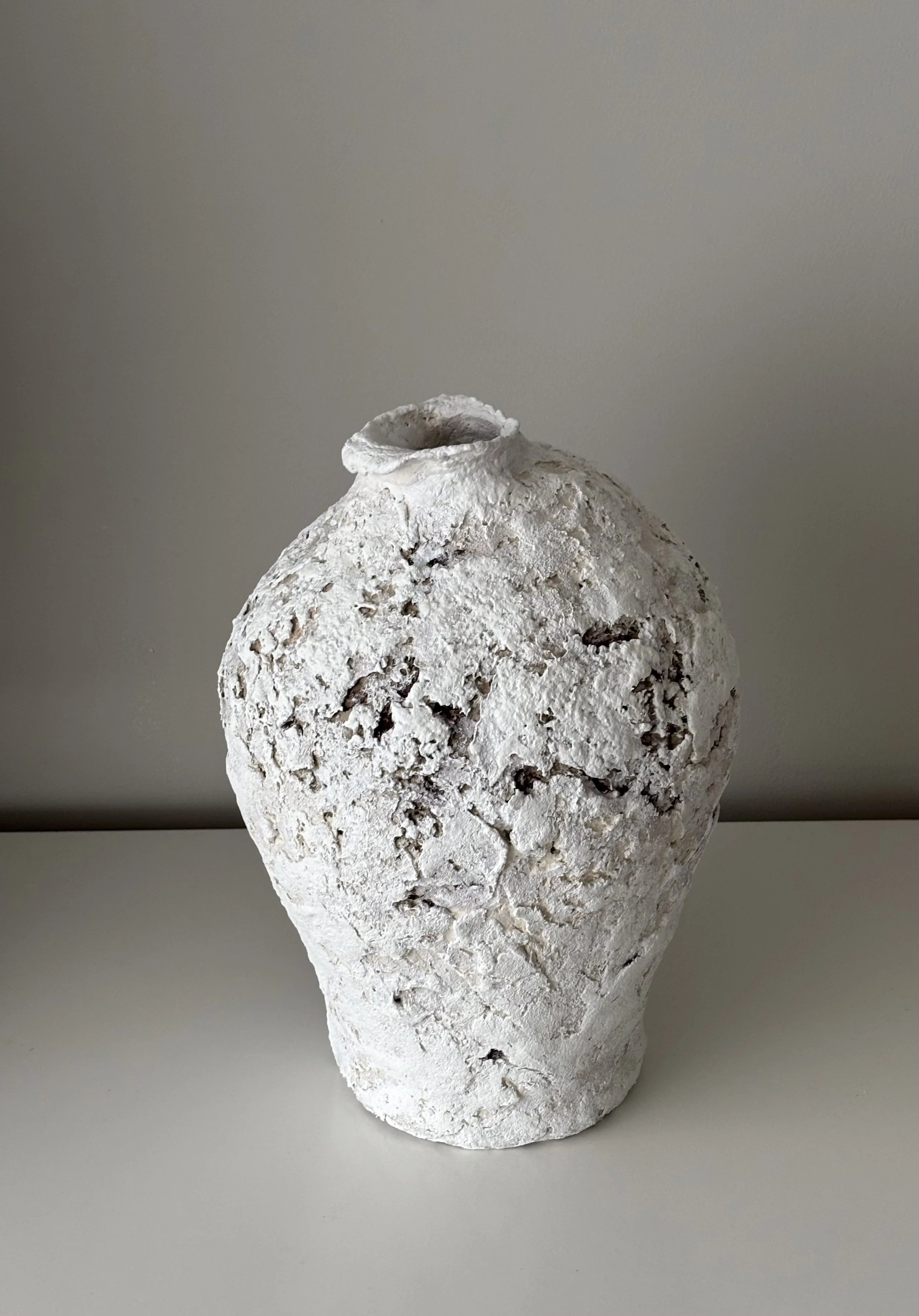 Three-quarter view of Textured Vessel N.22, off-white textured paper clay vessel with organic irregular form, minimalist sculptural home decor