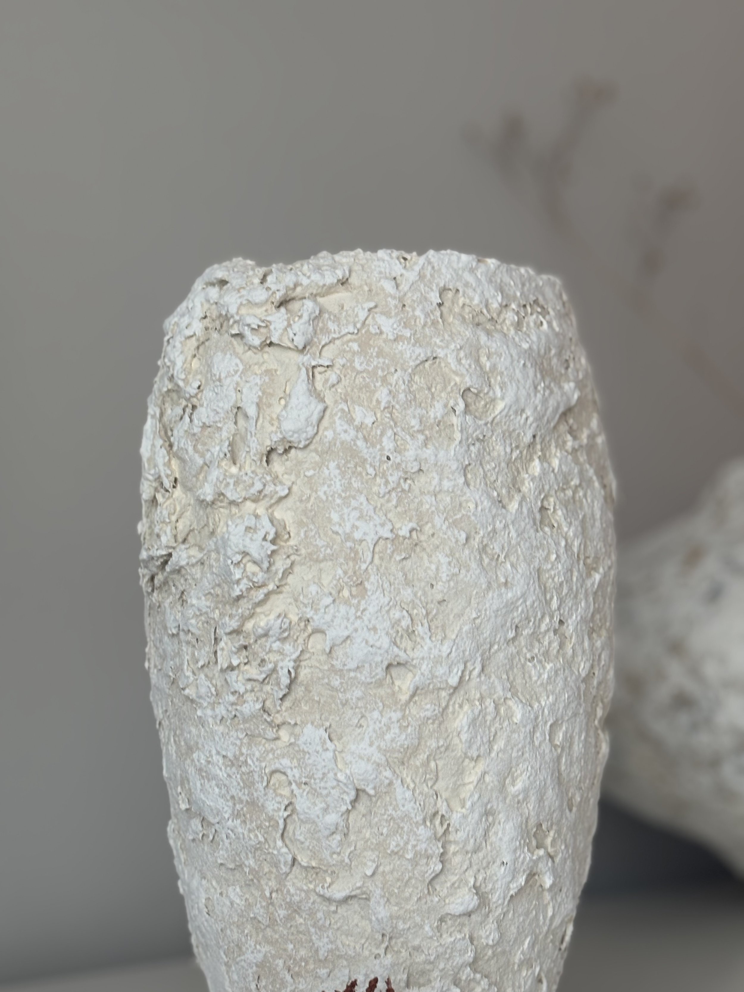 Rear view of Ecru And White Tones Textured Vase N.13 in ecru and white tones paper clay, showing organic asymmetry from behind, from Papier Atelier London