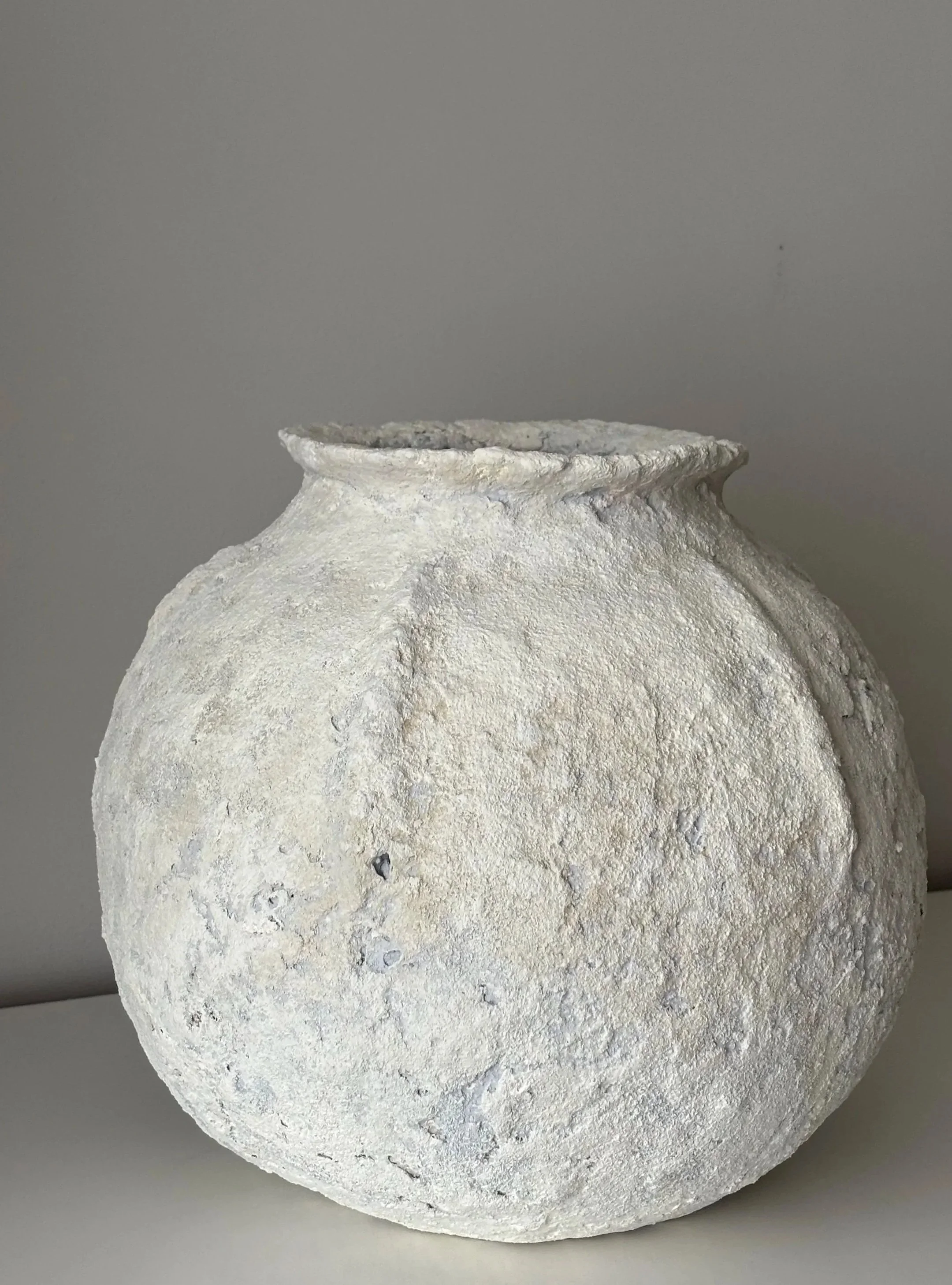 Textured Vessel N.11, off-white paper clay vessel viewed from an alternate angle highlighting asymmetrical shape, from Papier Atelier London
