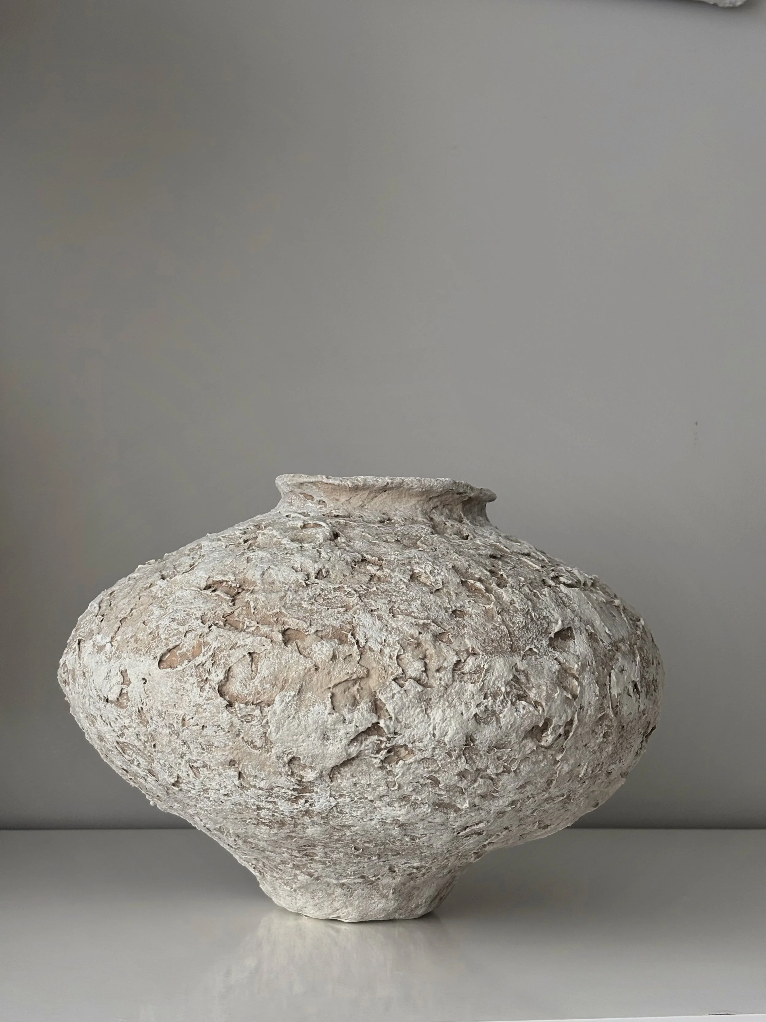 Sculptural Vessel N.20 from an angled perspective, off-white handcrafted paper clay vessel with irregular organic edges, handmade in London