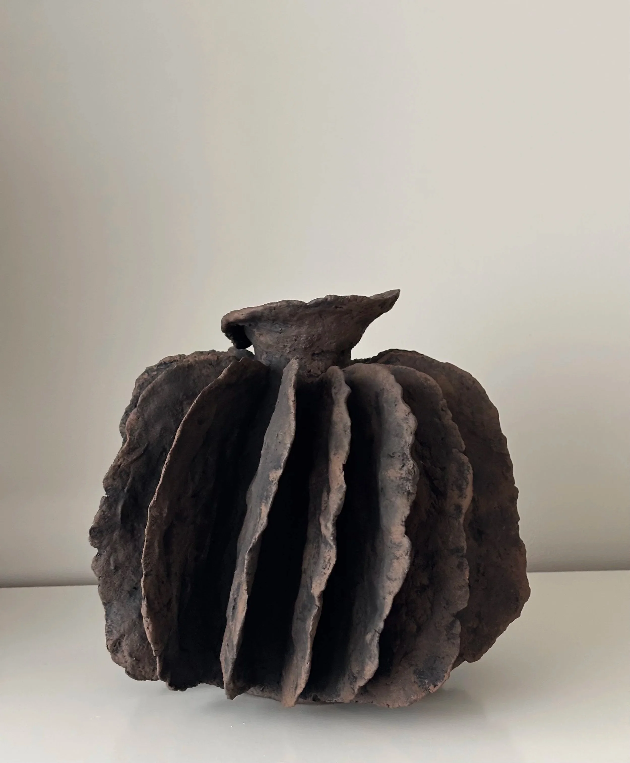 Textured Pleated Vessel N.8 from an angled perspective, off-white Wabi-Sabi inspired paper clay vessel with irregular organic edges, London atelier