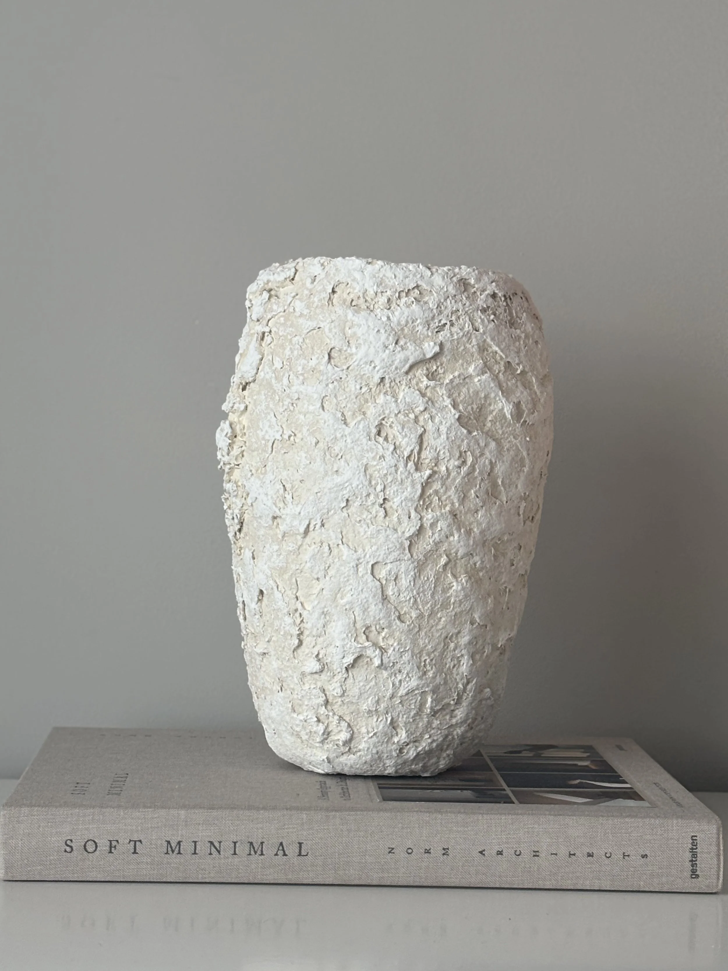 Three-quarter view of Ecru And White Tones Textured Vase N.13, ecru and white tones textured paper clay vase with organic irregular form