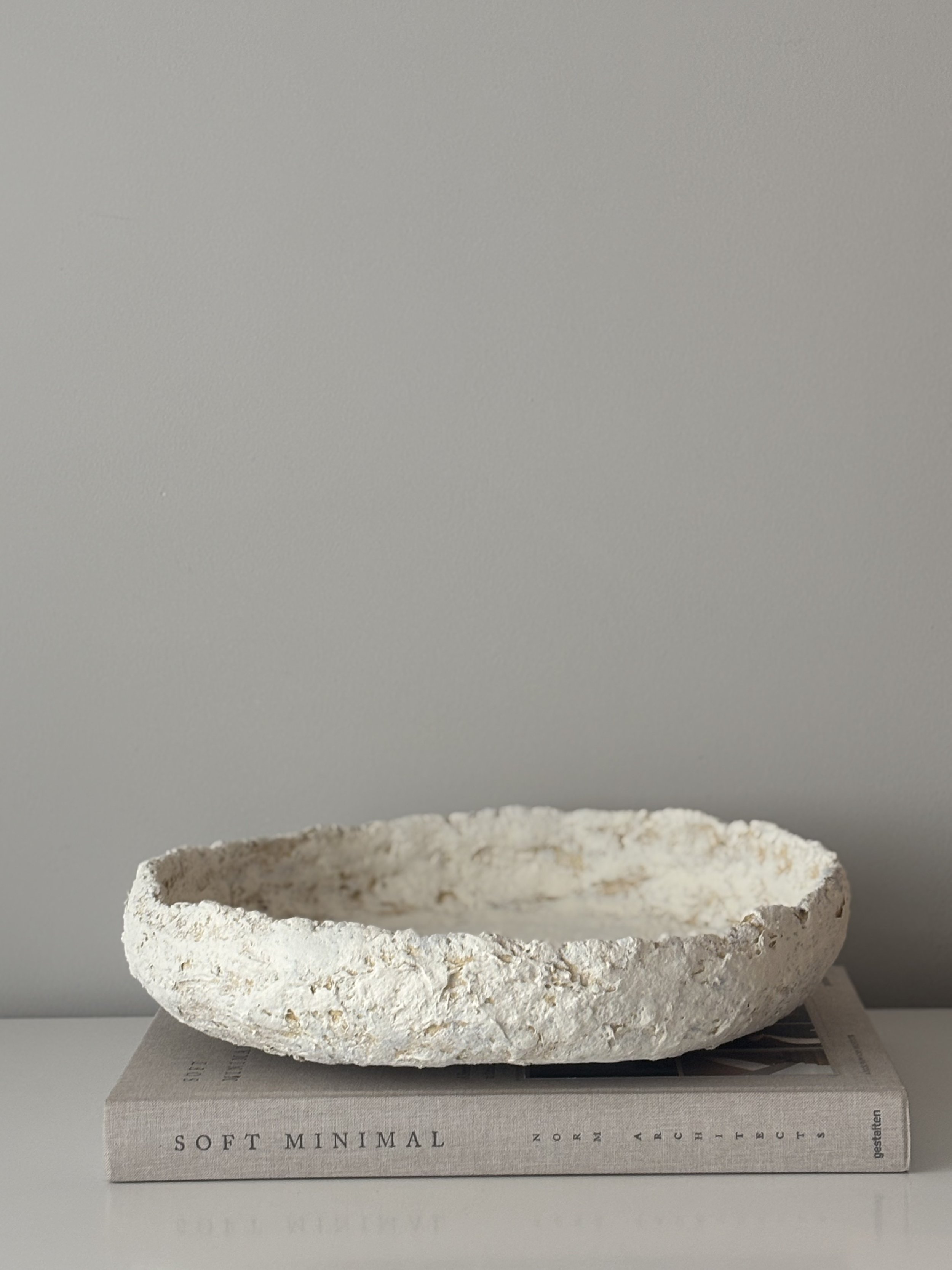 Three-quarter view of Layered Tray N.19, off-white textured paper clay tray with organic irregular form, minimalist sculptural home decor