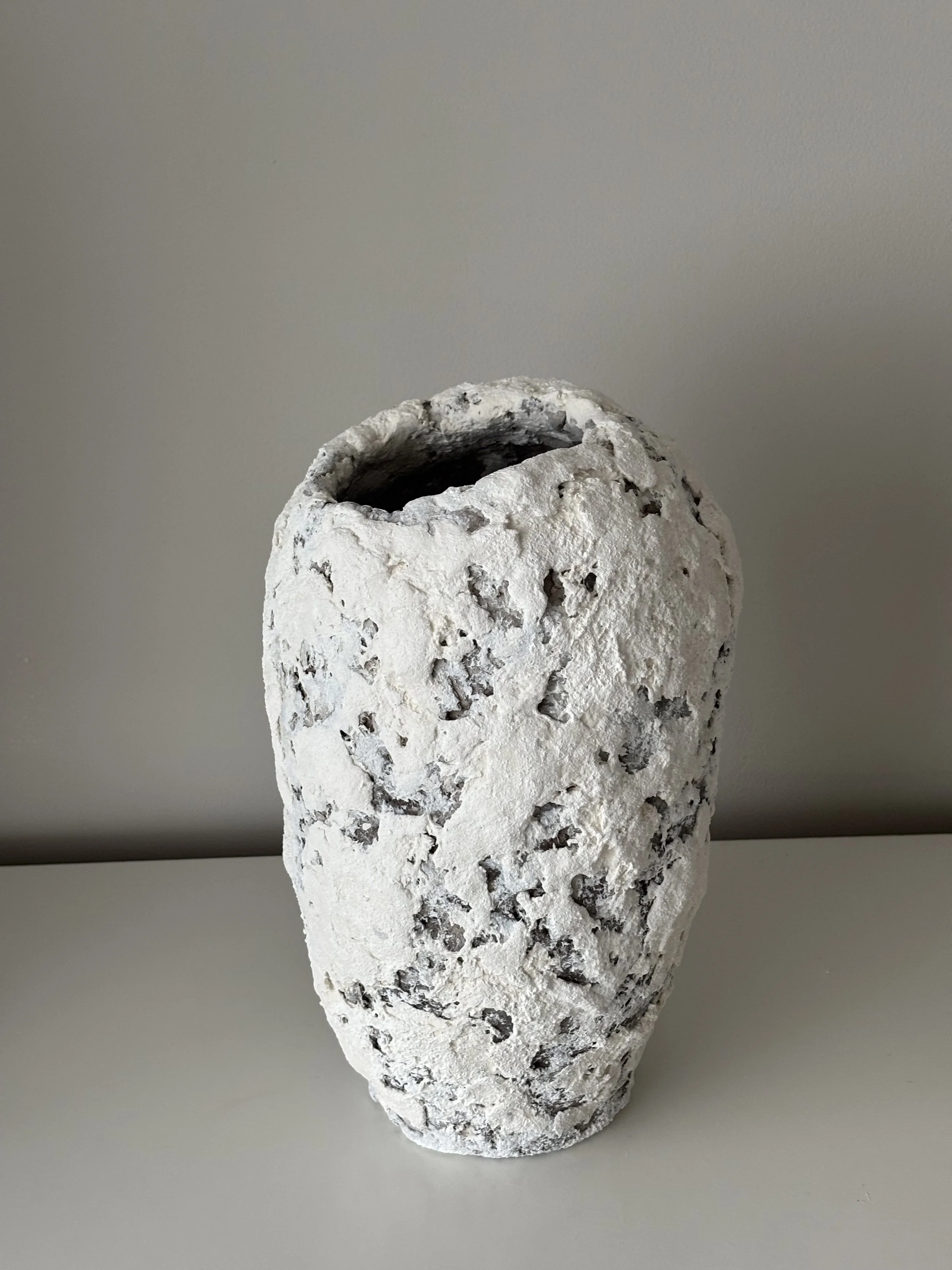Three-quarter view of Textured White Vase N.41, white textured paper clay vase with organic irregular form, minimalist sculptural home decor