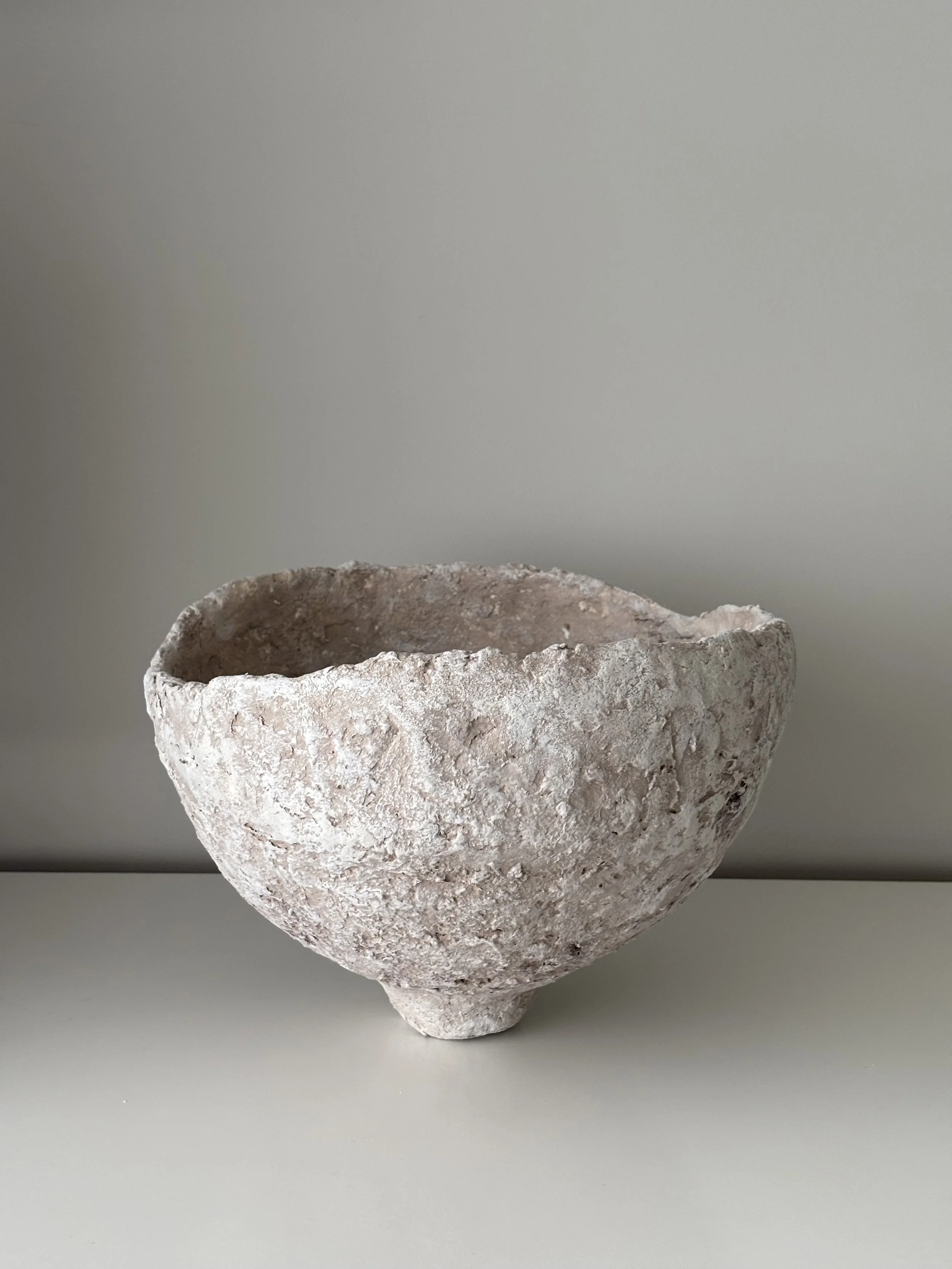 Three-quarter view of Asymmetric Wabi Sabi Bowl N.9, off-white textured paper clay bowl with organic irregular form, minimalist sculptural home decor