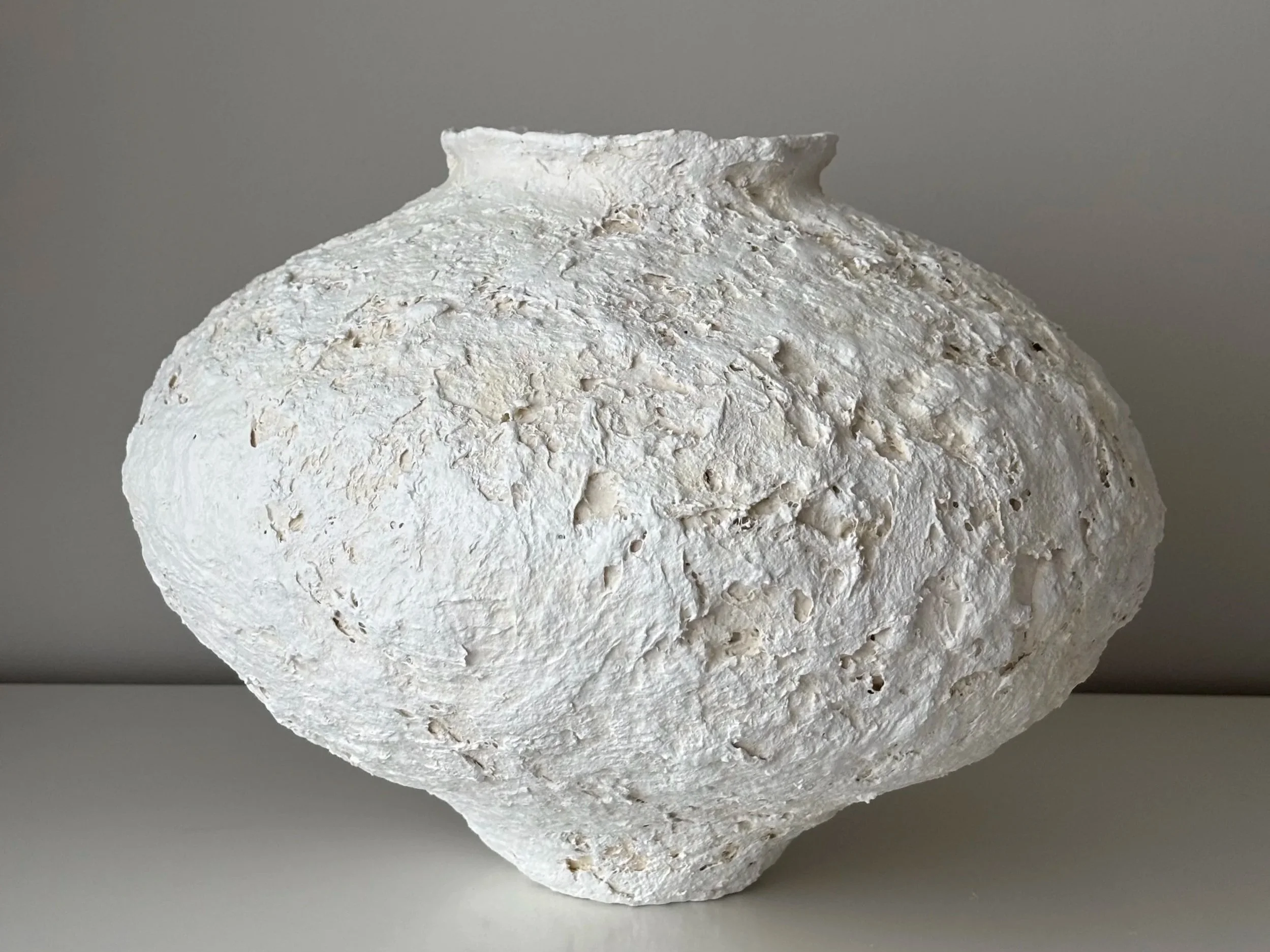 Textured Organic Vessel N.38, off-white paper clay vessel viewed from an alternate angle highlighting asymmetrical shape, from Papier Atelier London