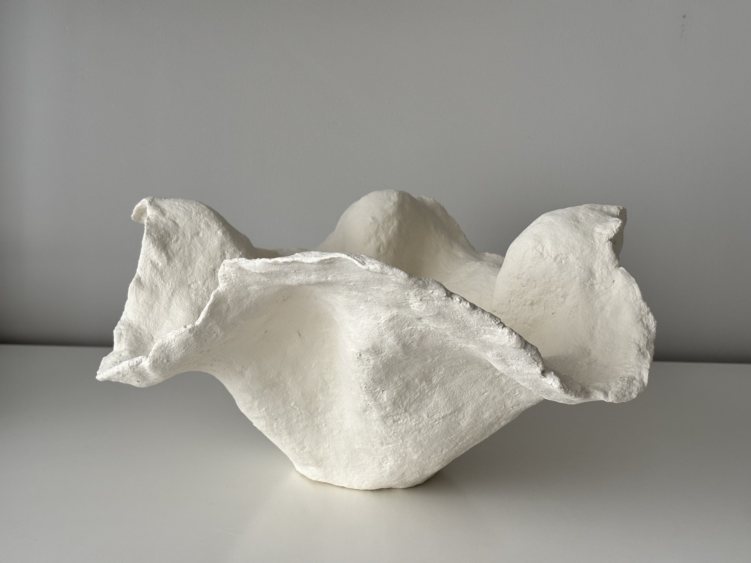 Three-quarter view of Handkerchief White Bowl N.33, white textured paper clay bowl with organic irregular form, minimalist sculptural home decor