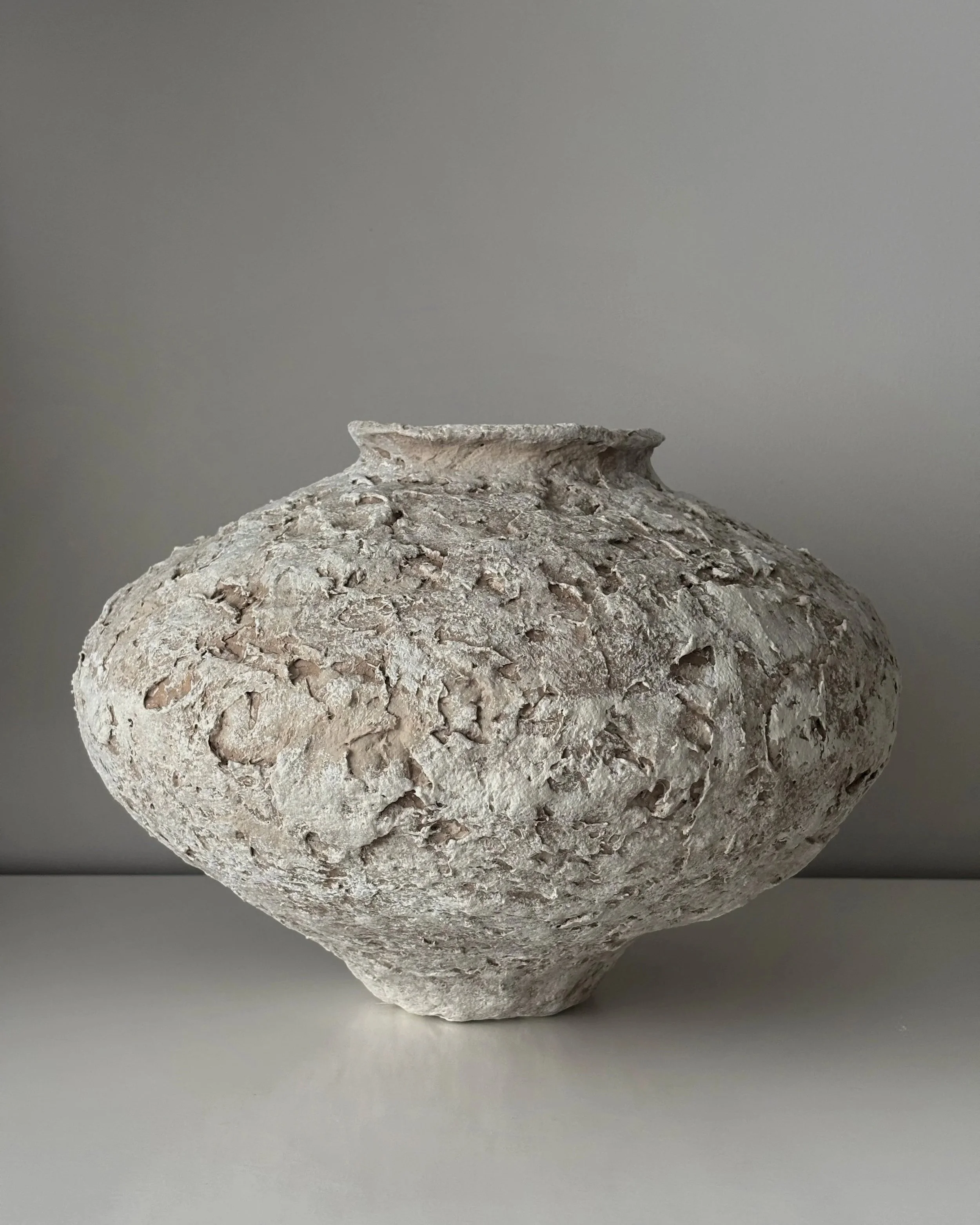 Sculptural Vessel N.20, off-white paper clay vessel viewed from an alternate angle highlighting asymmetrical shape, from Papier Atelier London