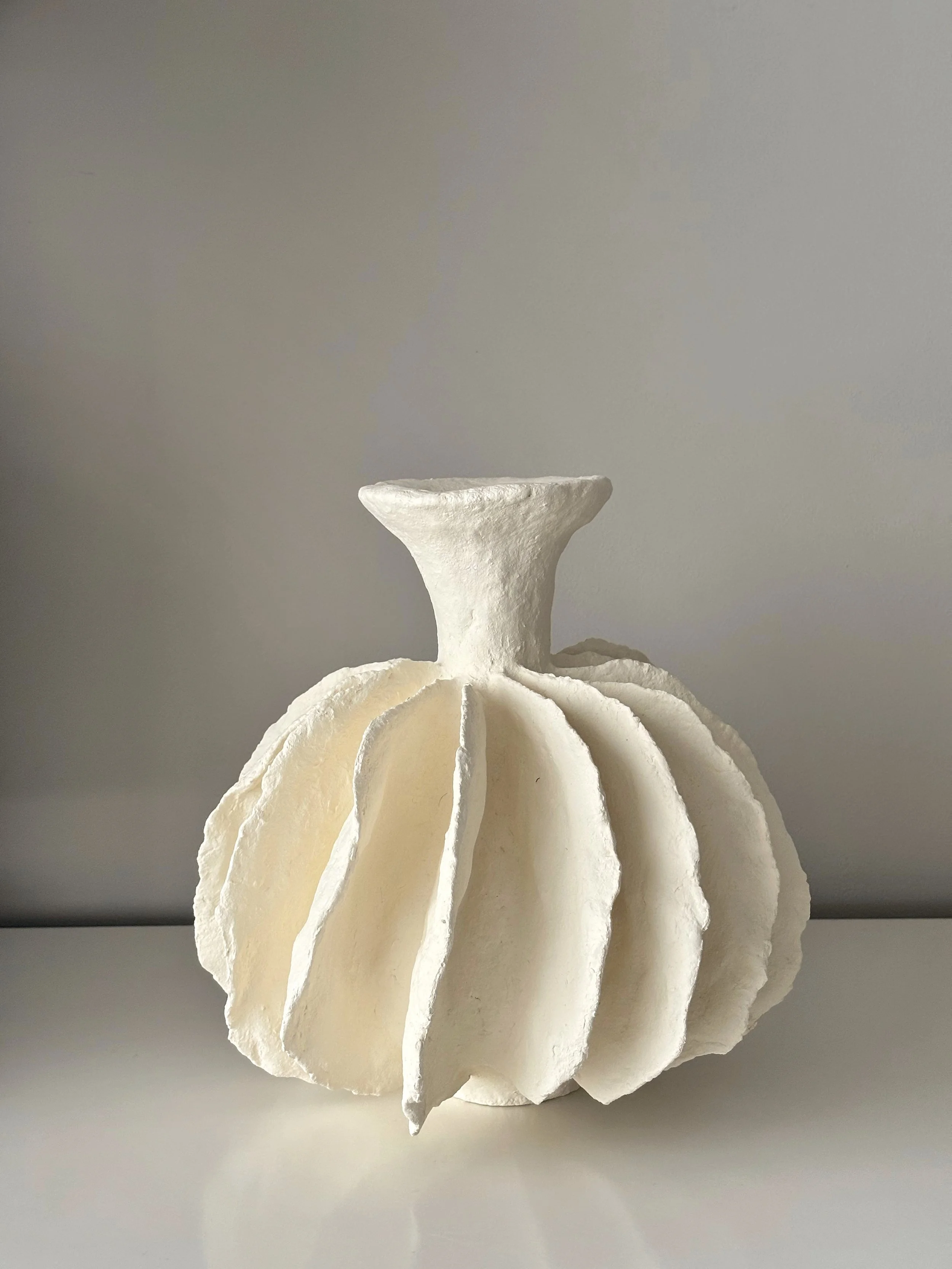 Pleated Sculptural Vase N.10 from an angled perspective, off-white handcrafted paper clay vase with irregular organic edges, handmade in London
