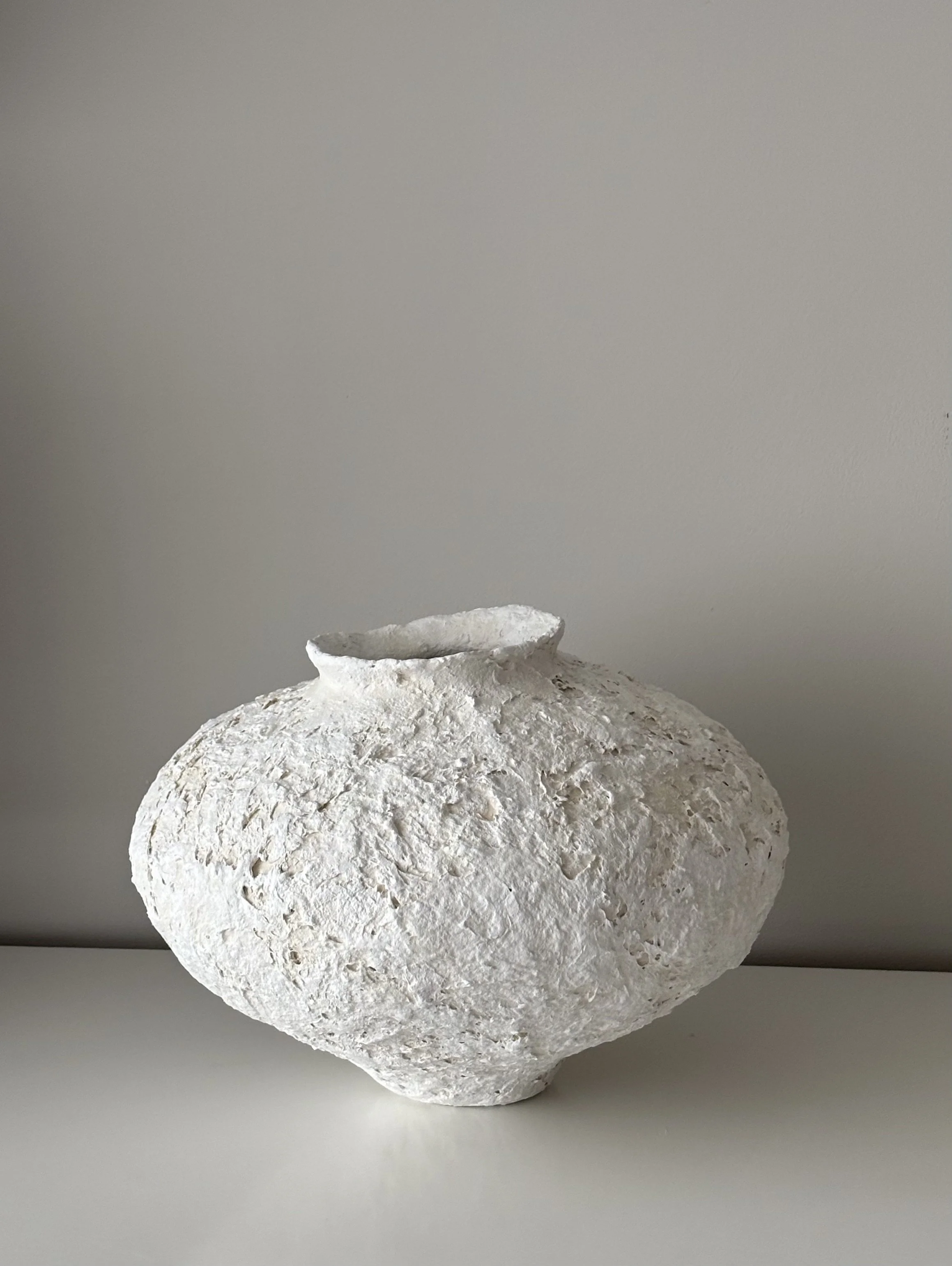 Rear view of Textured Organic Vessel N.38 in off-white handcrafted paper clay, showing organic asymmetry from behind, handmade in London