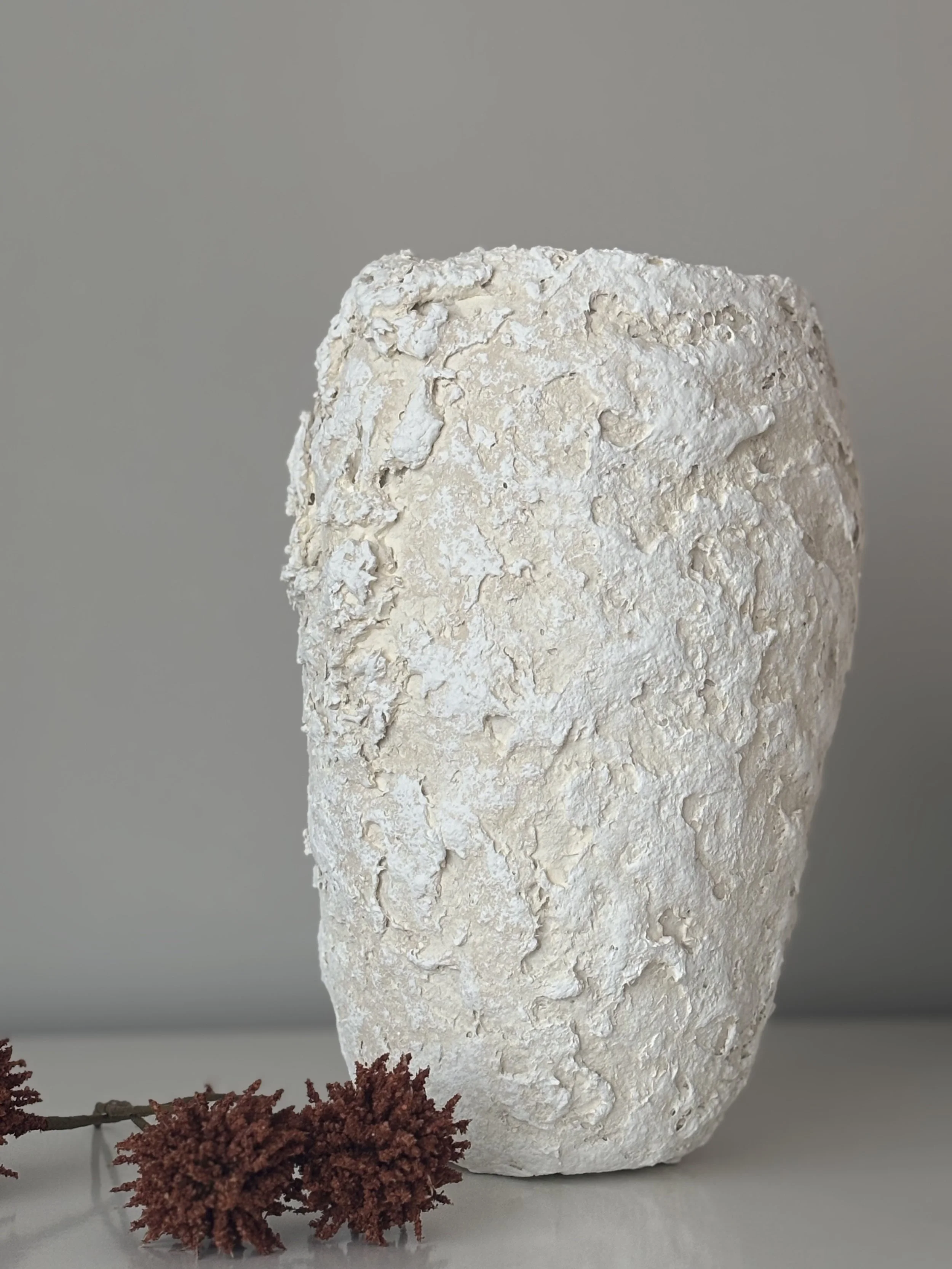 Ecru And White Tones Textured Vase N.13 from an angled perspective, ecru and white tones handcrafted paper clay vase with irregular organic edges