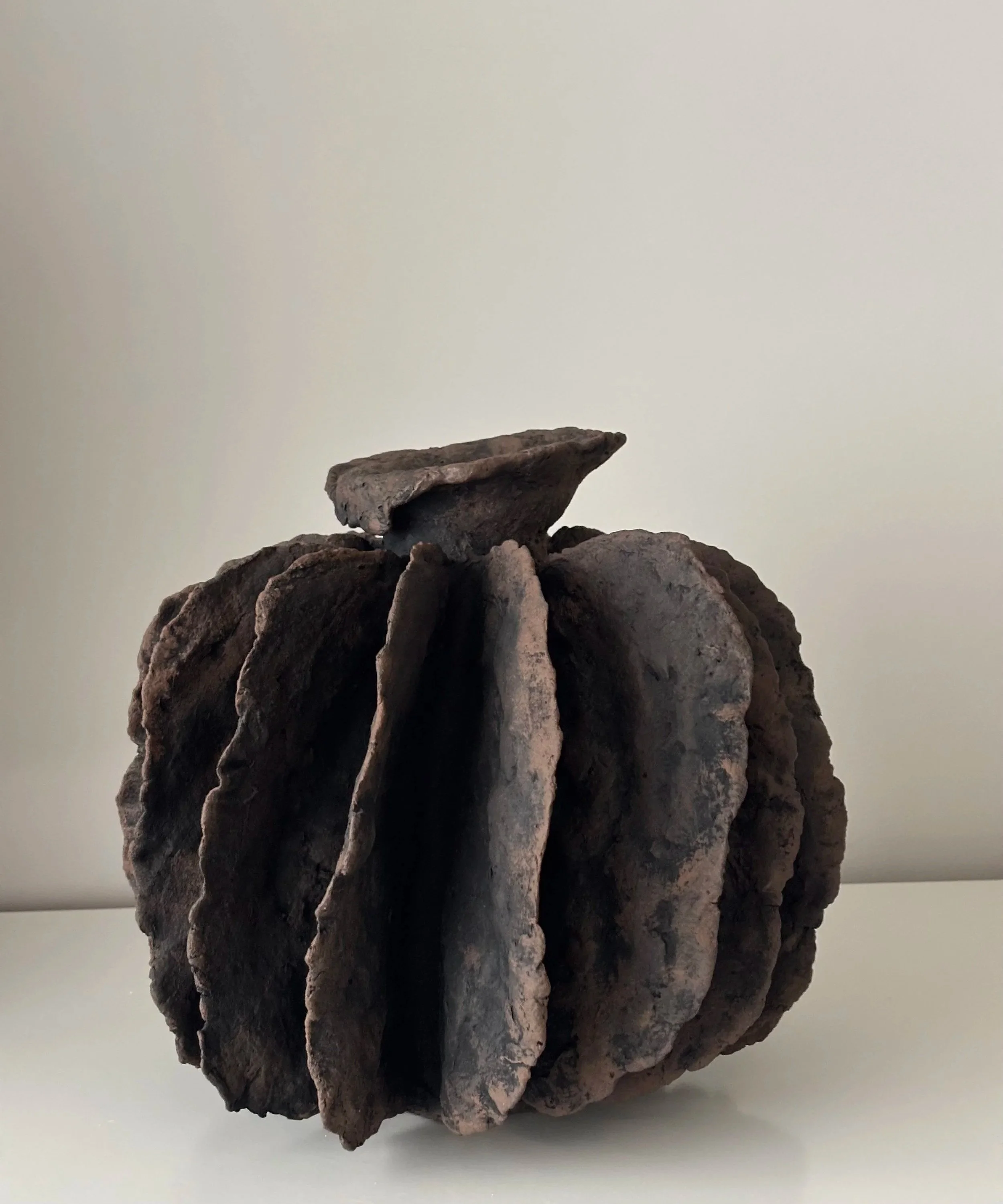 Side profile of Textured Pleated Vessel N.8 in sculptural paper clay, showing the sculptural silhouette and textured surface, unique handcrafted pottery