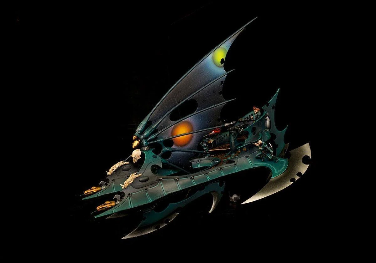 Futuristic spacecraft resembling a butterfly with intricate designs and small figures on it, set against a black background.