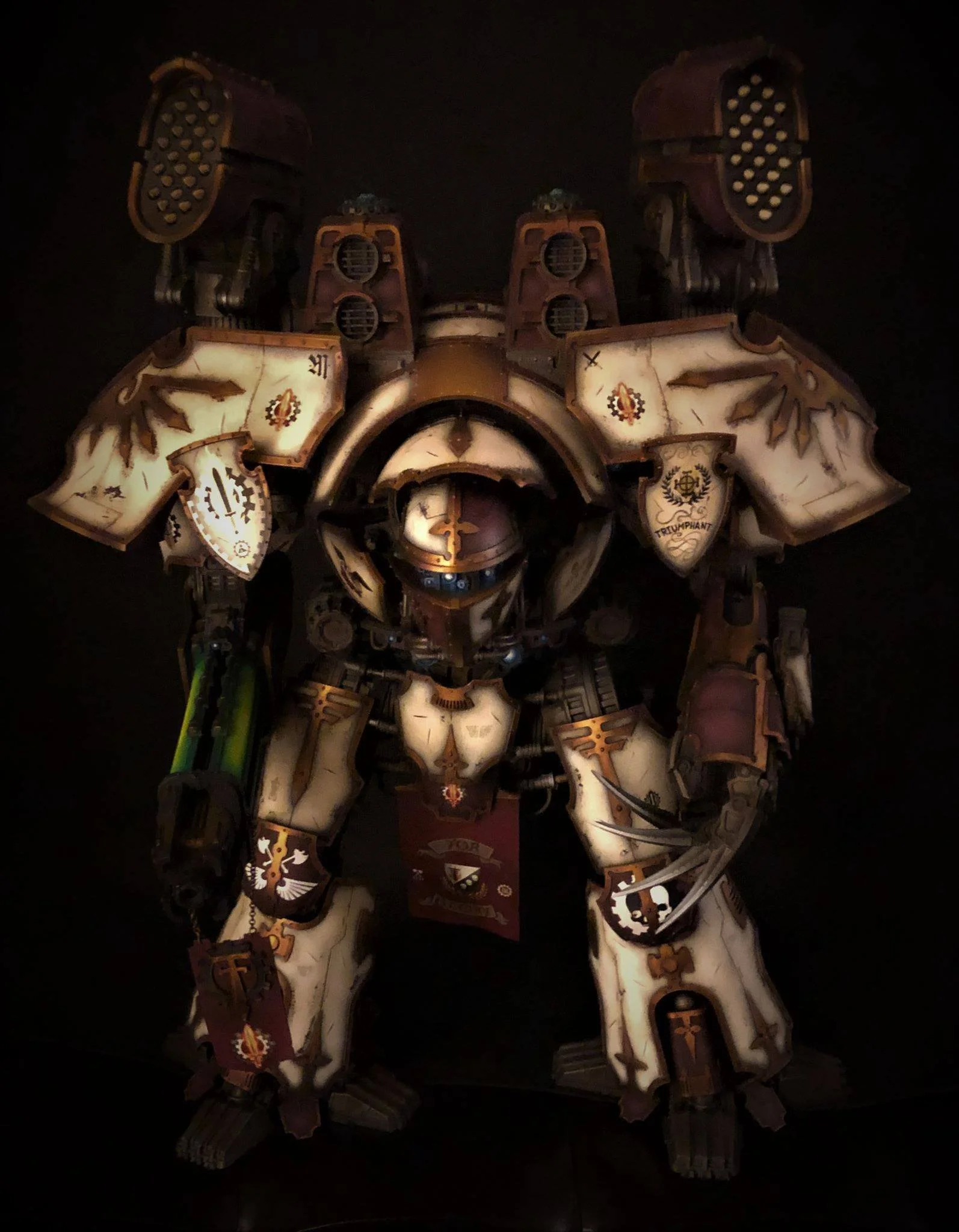 A detailed model of a Warhammer 40K Space Marine in white armor with gold and black accents, holding a gun with a green energy barrel.