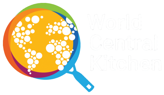 Logo with a globe made of connected white dots, surrounded by colorful arcs, and text that reads 'World Central Kitchen' in white.