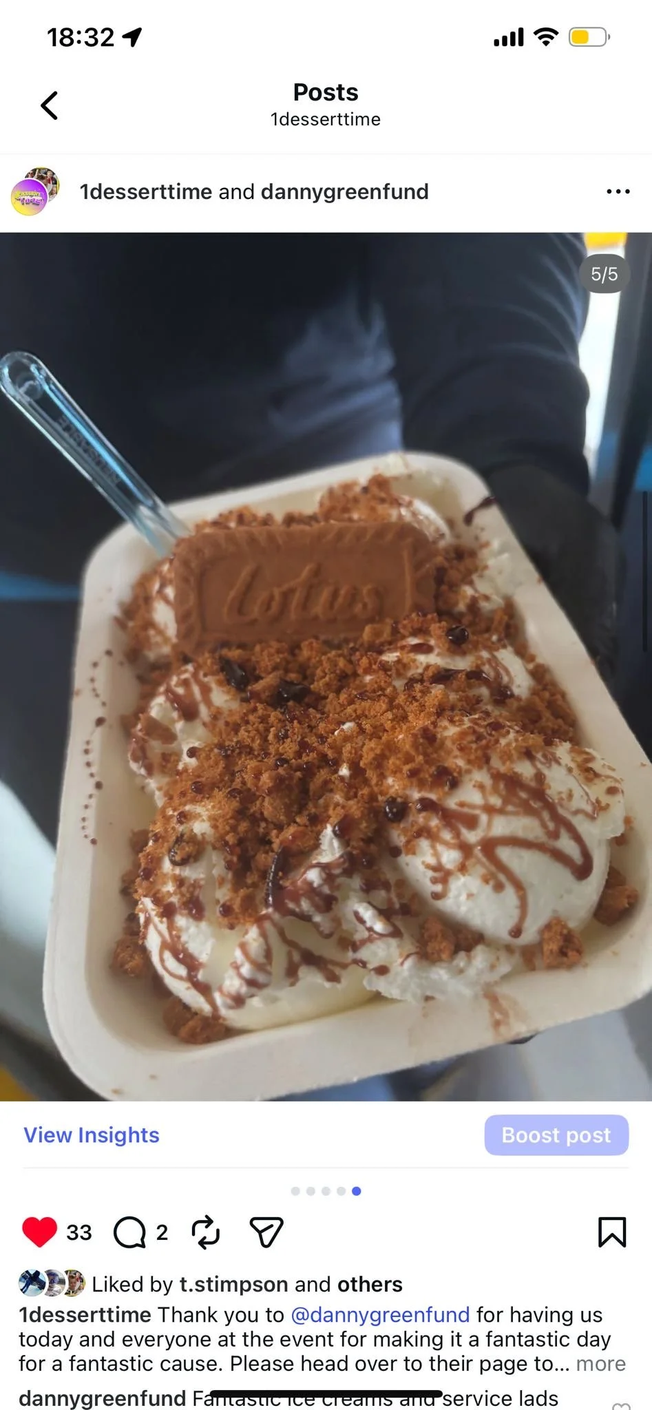 A bowl of ice cream topped with crumbled cookies, chocolate drizzle, and a Lotus biscuit.