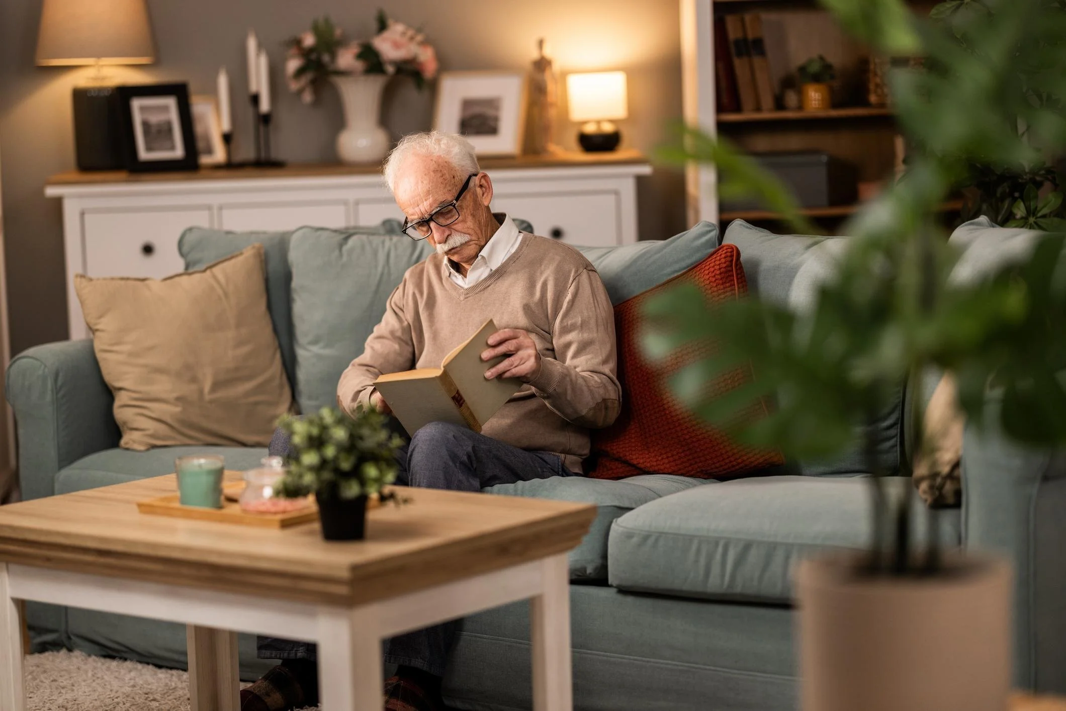 older man reading on couch