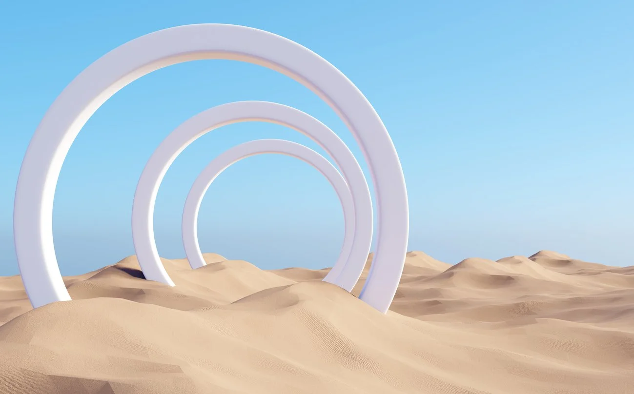 White arches receding into the distance across sand dunes under a blue sky — a visual metaphor for building health strategy in layers over time