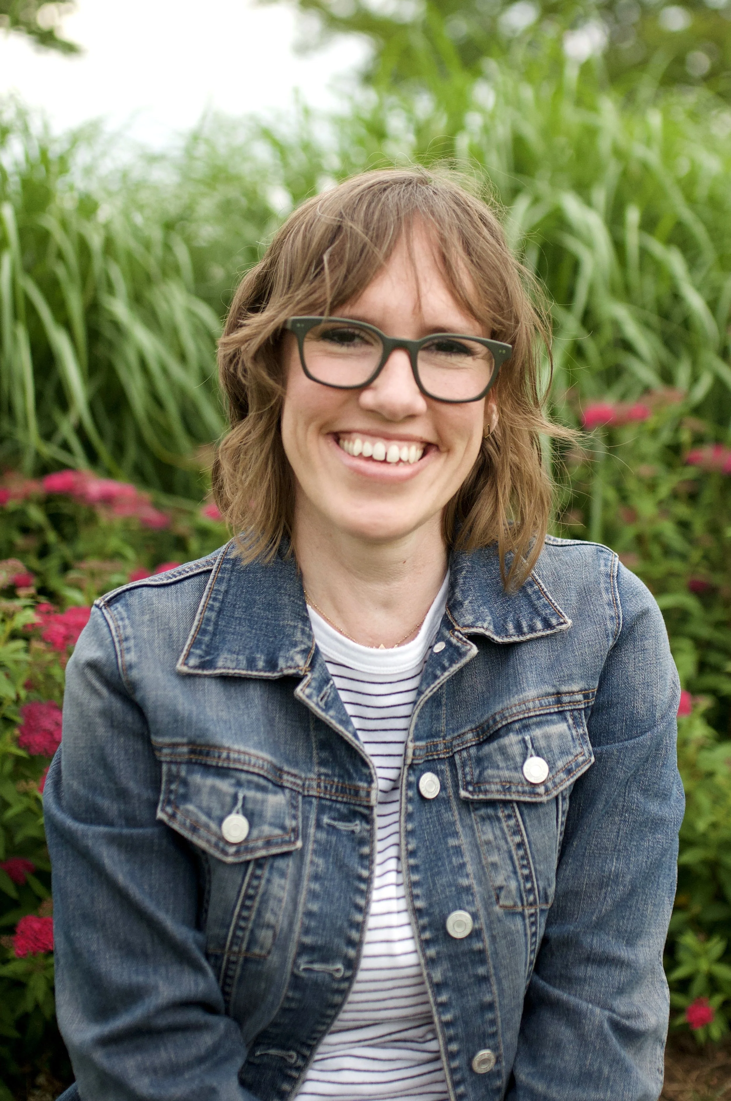 Headshot of Kara Holthaus LCPC of Heart Centered Therapy LLC offering telehealth in Maryland and DMV area. Photo is from waist up and shows Kara smiling and demonstrating a personal and warm approach with floral background.