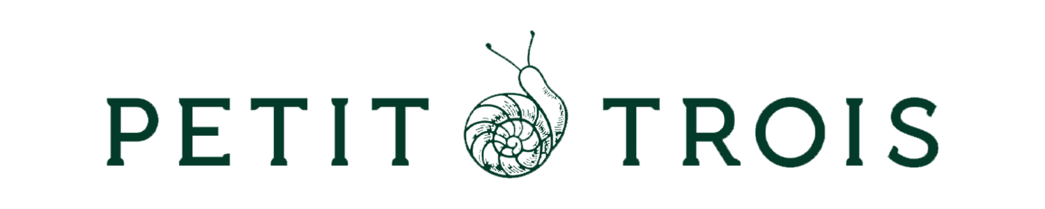 Logo for 'Petit Trois' restaurant with a nautilus shell icon in place of the letter 'O' in 'Trois'.