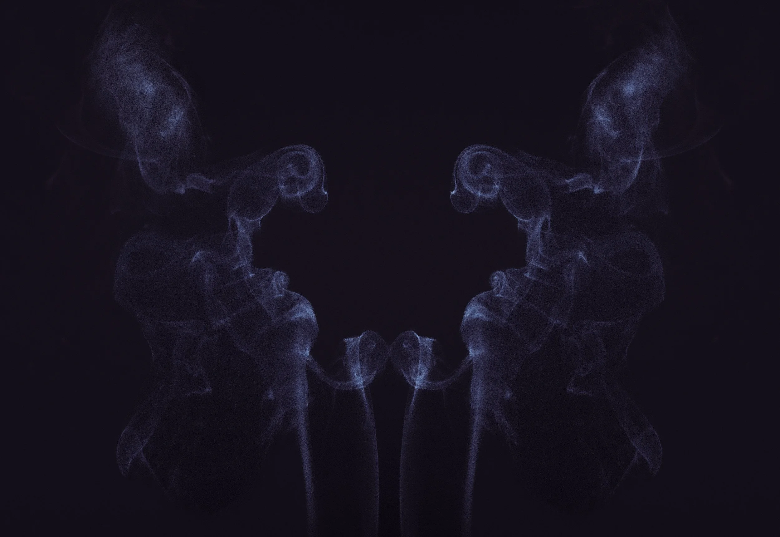 Symmetrical blue smoke patterns on a black background.