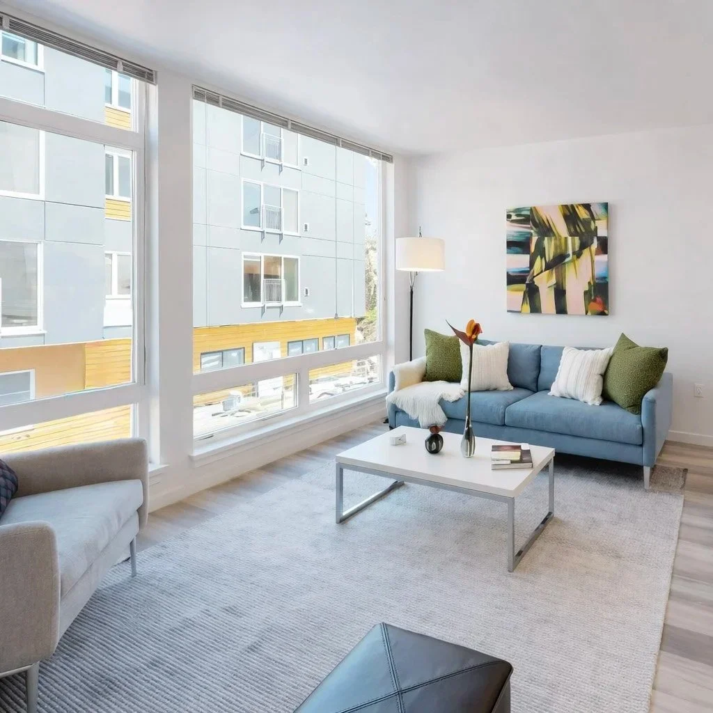 Bright living area with oversized windows at Ainsley Apartments in the U District.