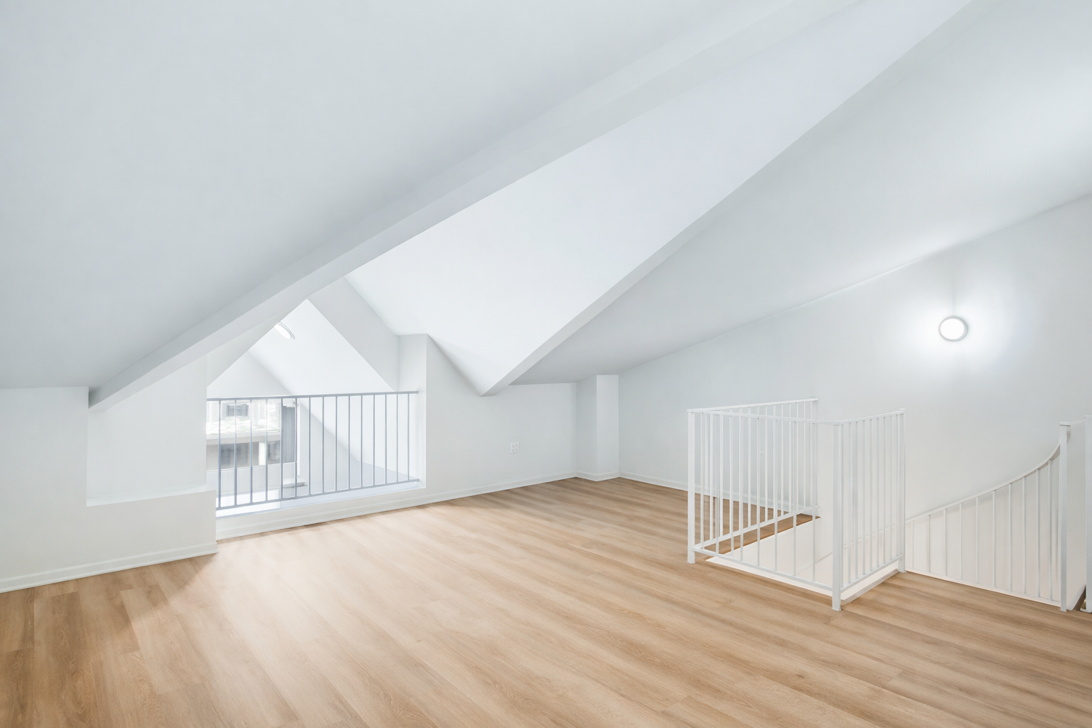 Loft-style room with vaulted ceilings and hardwood floors at Ainsley Apartments near UW.