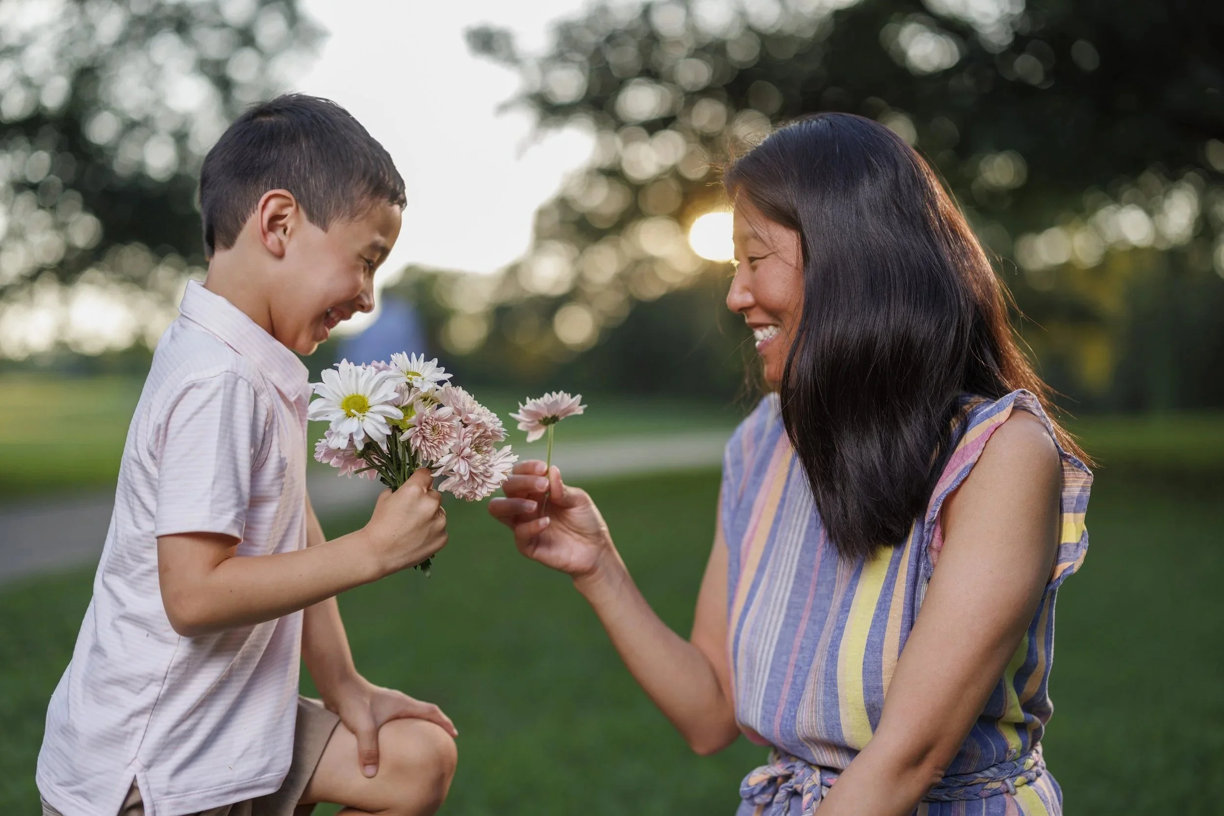 Young boy and his mom sharing flowers and smiling during a beautiful Decatur sunset – enjoying allergy-free outdoor moments with AllergyMD
