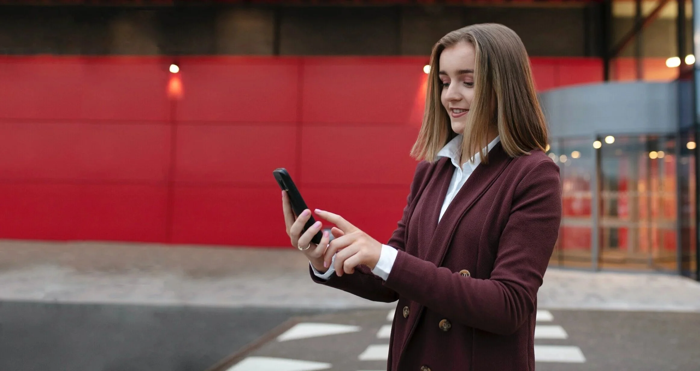A person working on an Apple iMac computer displaying a web page with a load of data, possibly a dashboard or report, in an office setting.