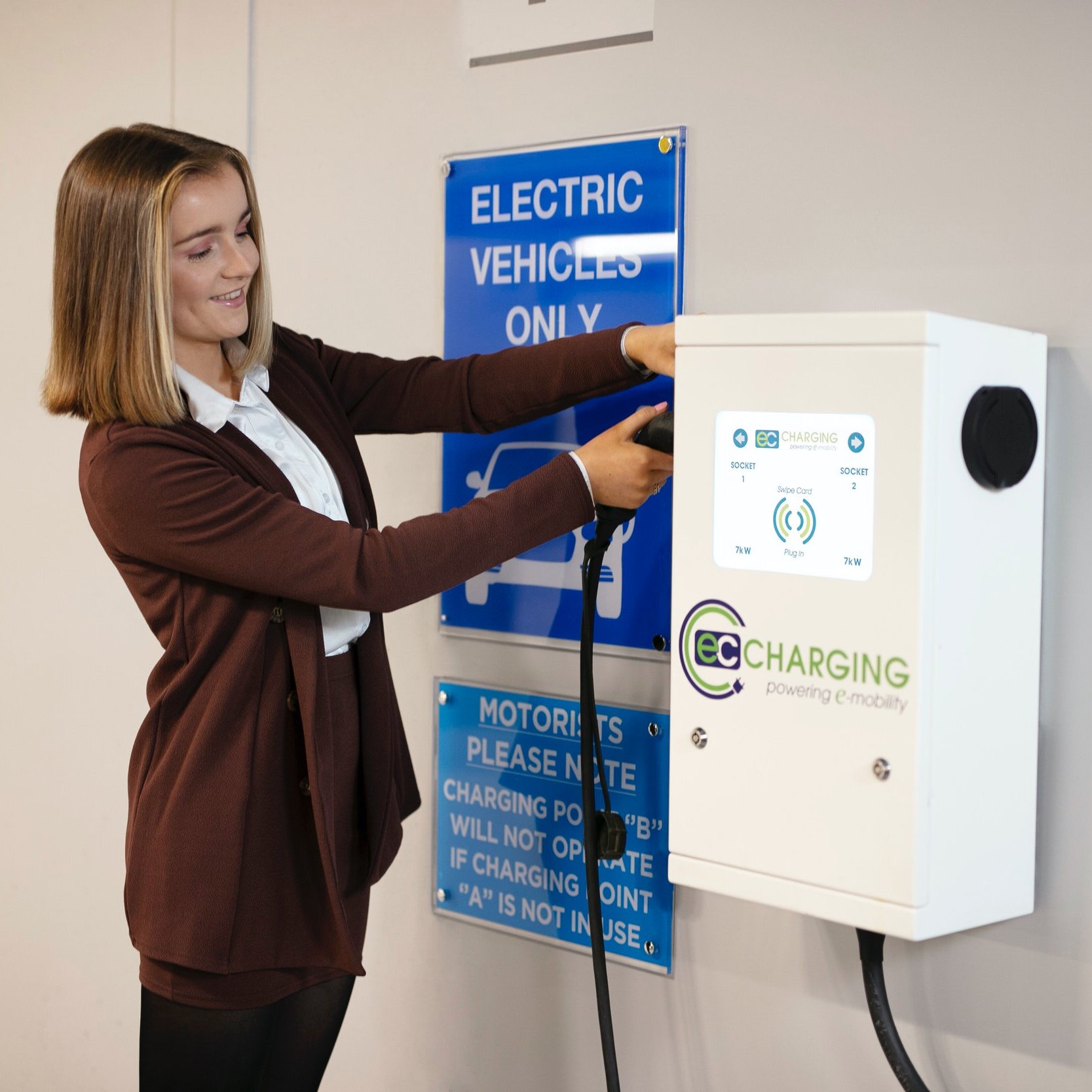 A woman making use of an EC Charging wall unit
