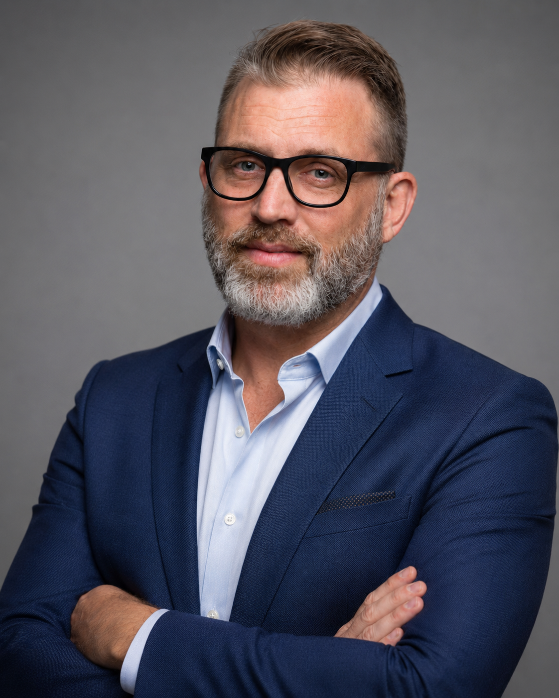Terry Wade, Principal of TLW Consulting, wearing a navy suit and glasses against a gray background.
