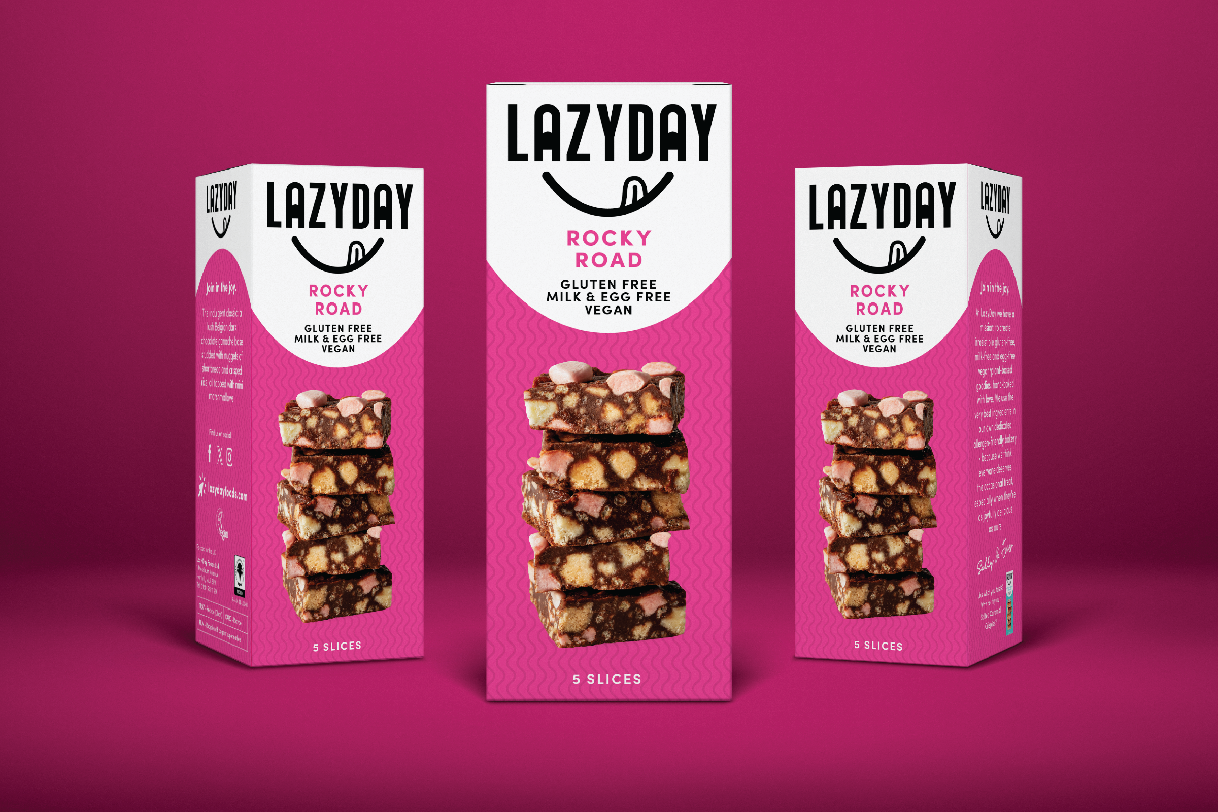 Three boxes of Lazyday Rocky Road vegan snack bars against a pink background, with an image of stacked snack bars on the front of each box.