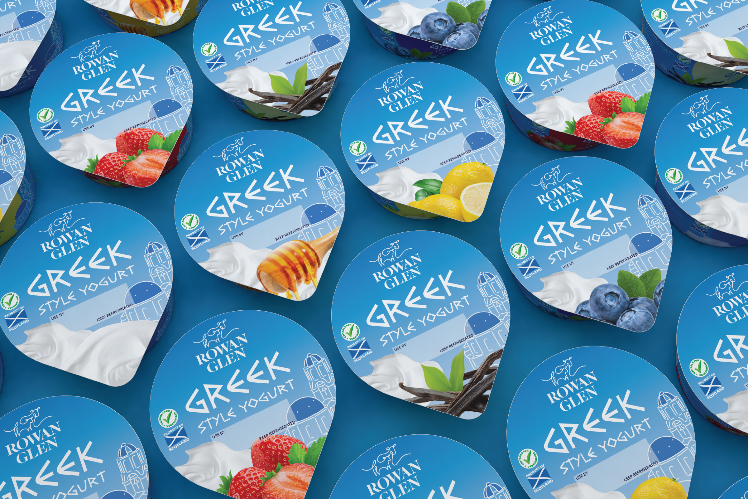 Multiple containers of Rowan Glen Greek Style Yoghurt, featuring flavors such as strawberry, blueberry, lemon, and honey, arranged on a blue surface.