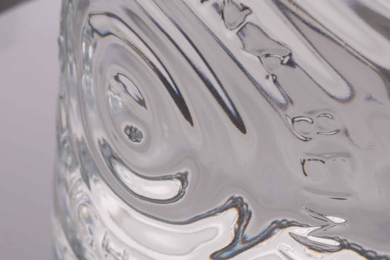 Close-up of a clear glass with reflections and distortions.