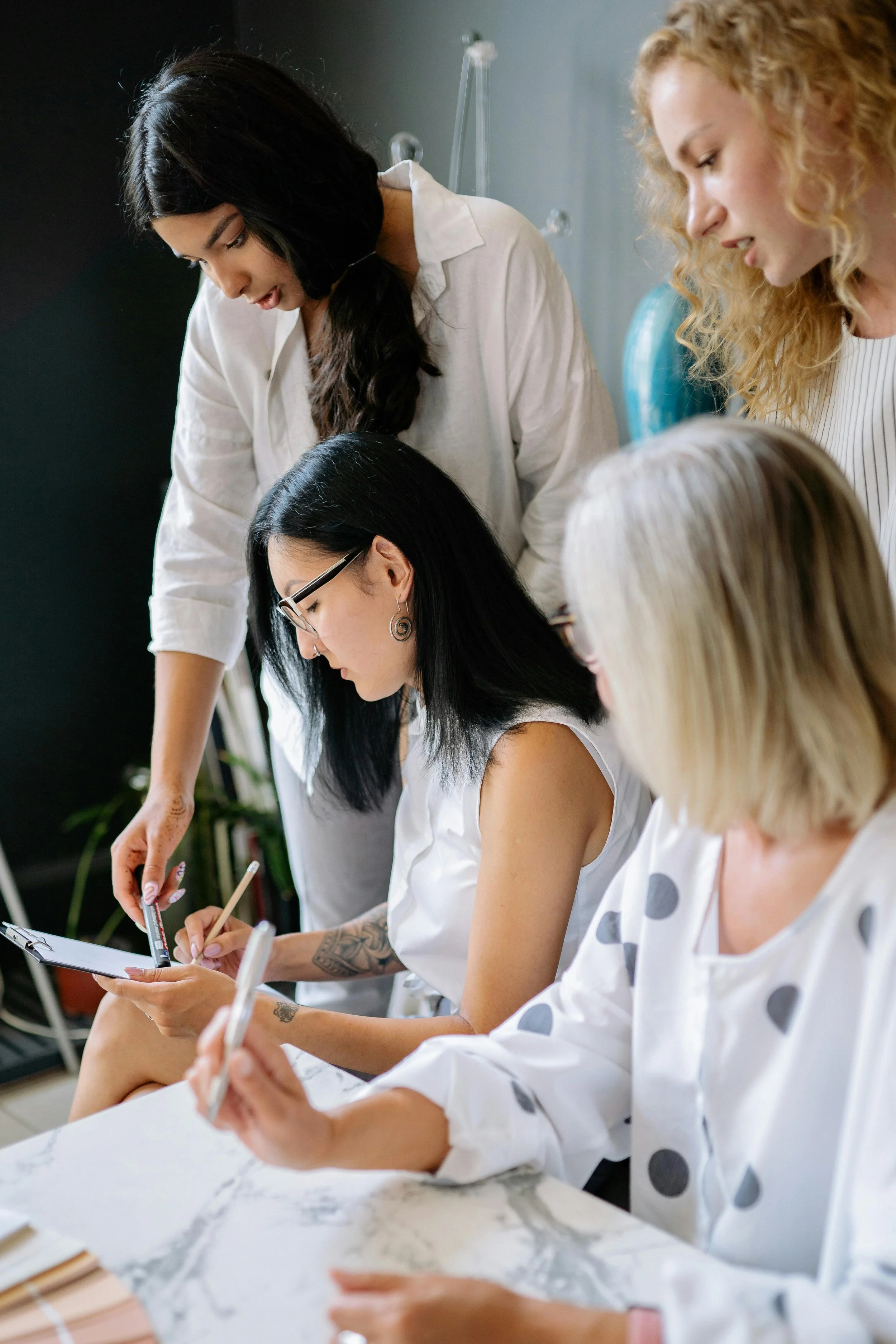 Women collaborating and taking notes during a compliance consulting session