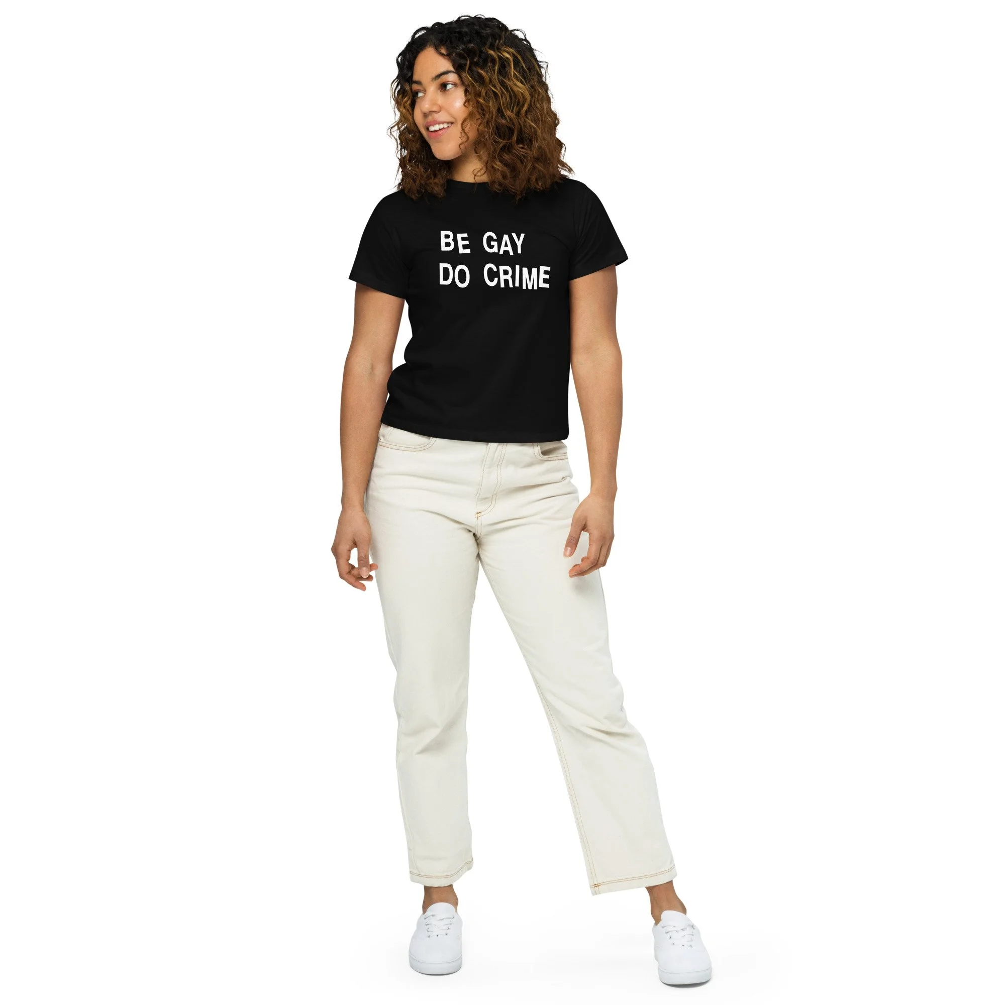 Women's high-waisted cropped t-shirt with 'Be Gay, Do Crime' graphic, front view on woman standing
