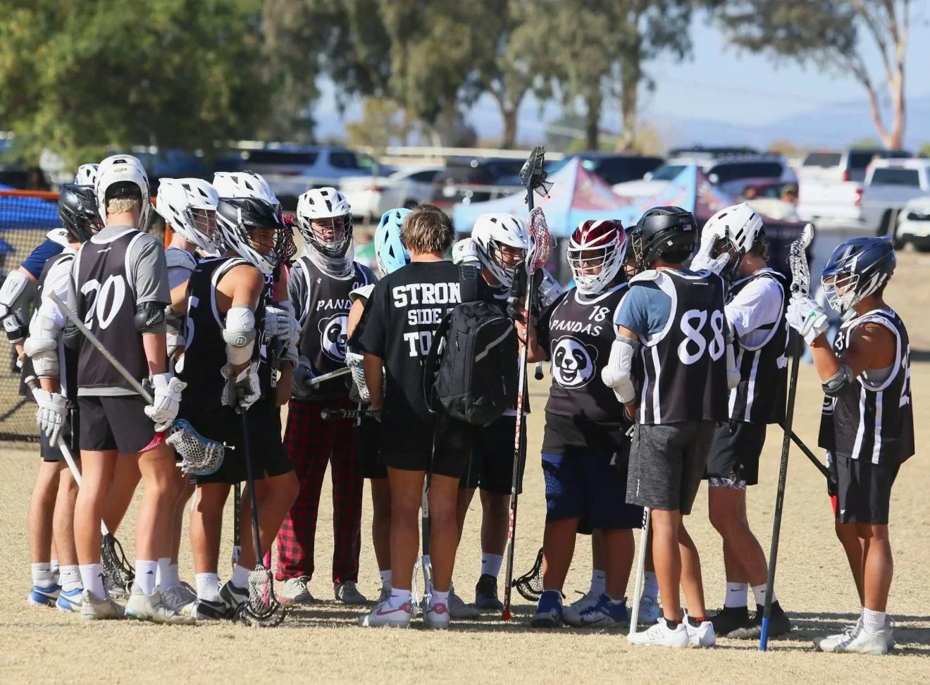 Coaches giving feedback and instruction to players at lacrosse practice