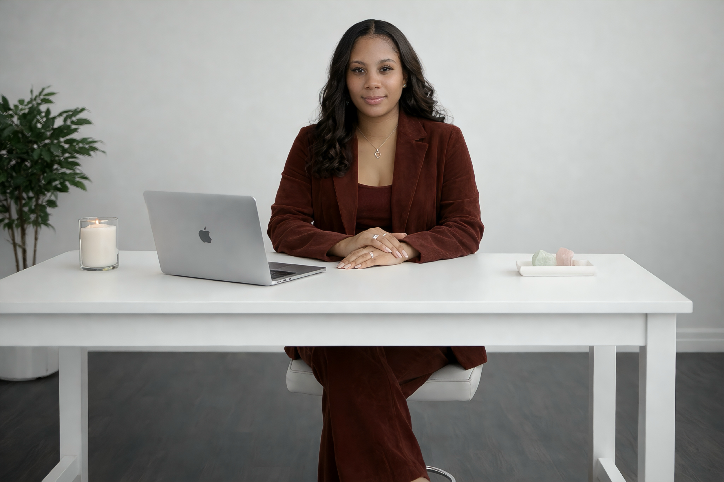 Anissia seated at a minimalist white desk, embodying clarity, confidence, and personal alignment while working on transformational guidance sessions.
