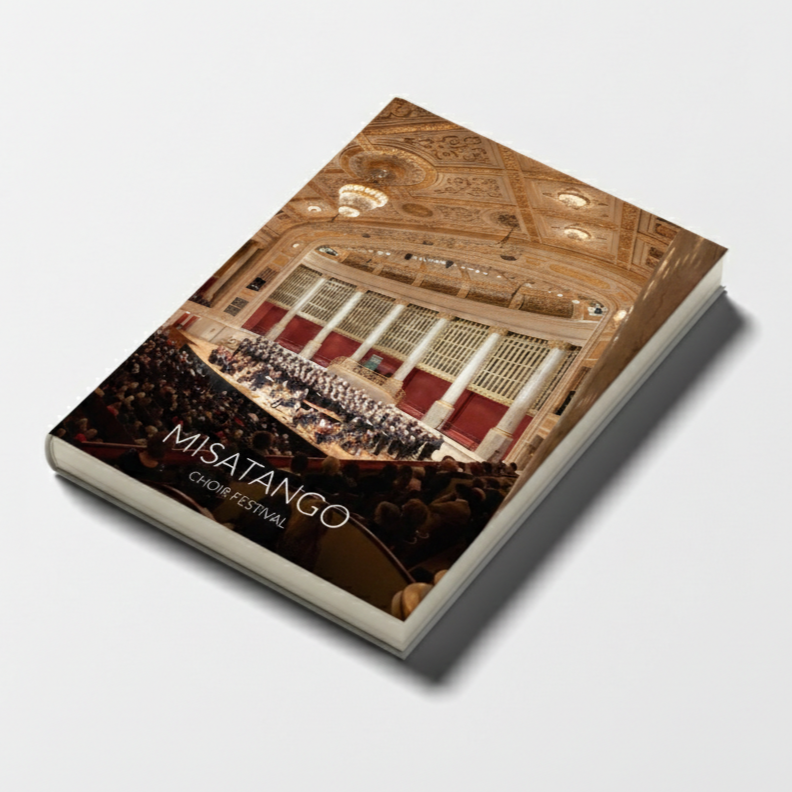 Program booklet for the Misatango Choir Festival showing an interior concert hall with ornate ceiling and chandelier, filled with an audience and performers on stage.