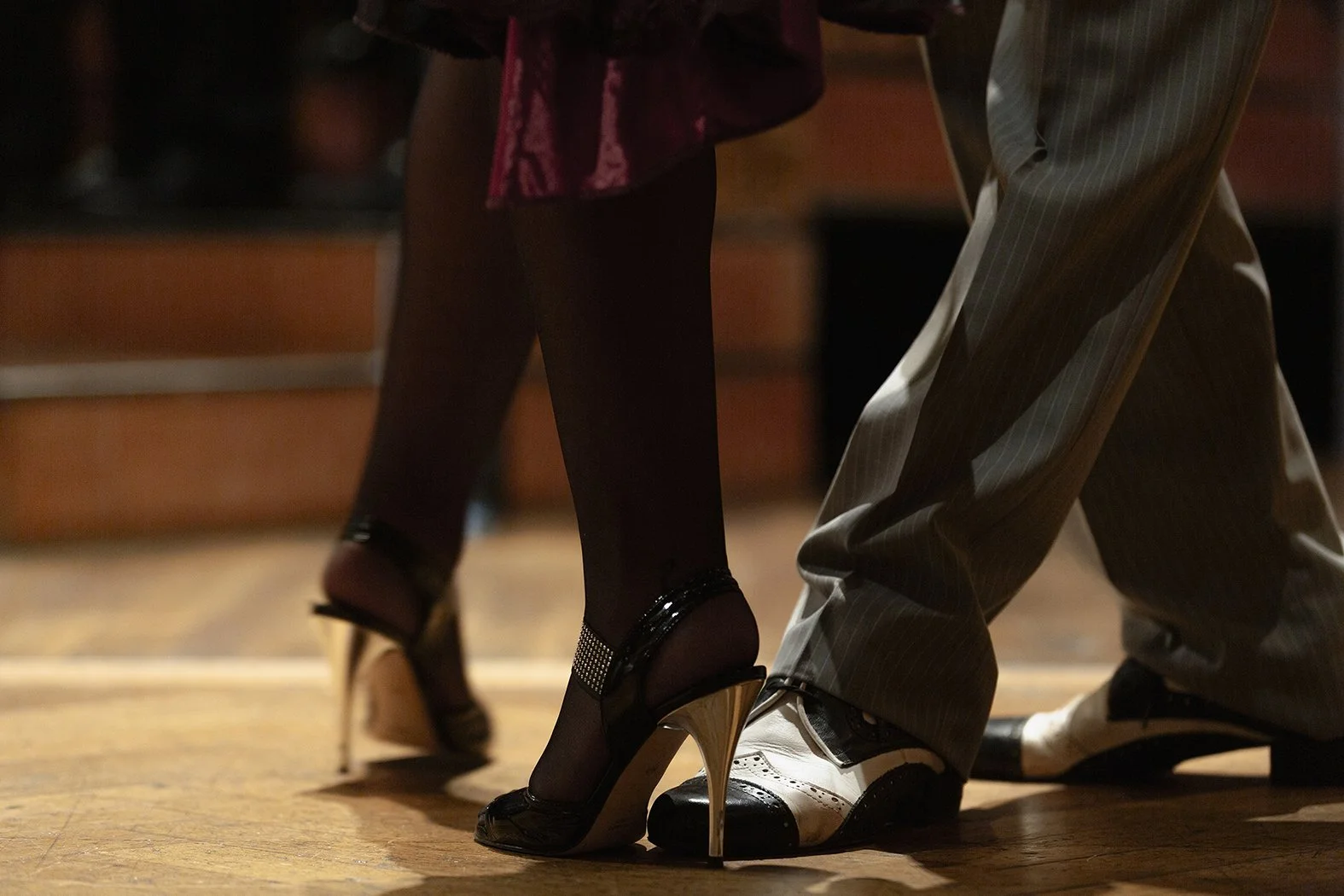 Pareja bailando tango, vestimenta elegante y calzado de baile.